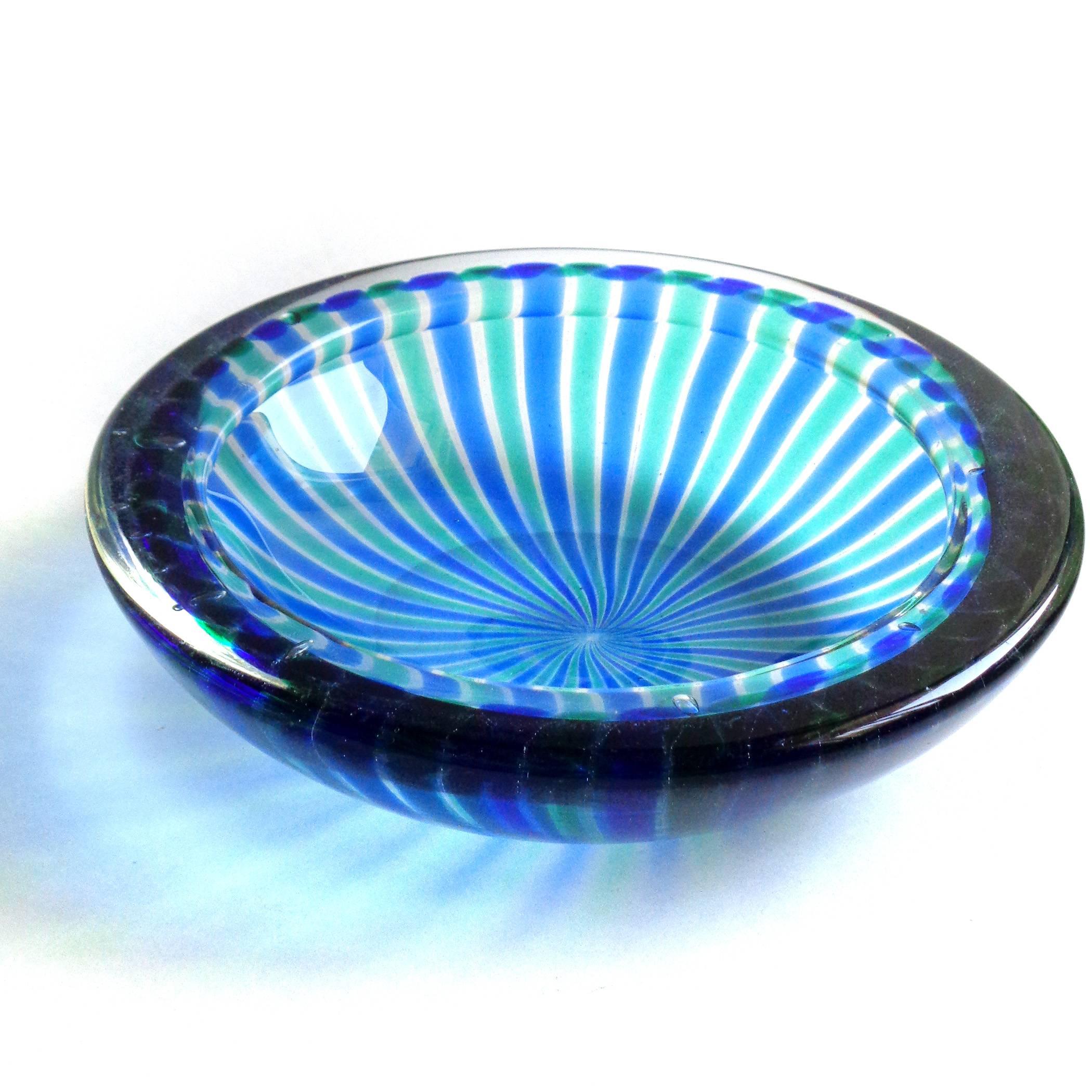 Incredible Murano hand blown cobalt blue and green ribbons art glass bowl.
Attributed to the Fratelli Toso company. The piece has a folded over rim and pinwheel design. A beautiful statement piece for any table!
