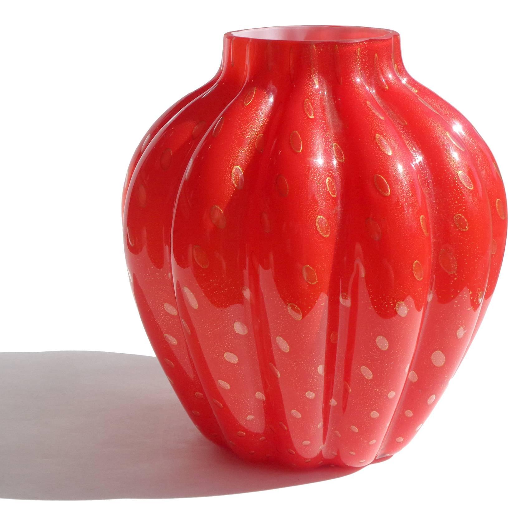 Beautiful Murano hand blown rich red, controlled bubbles and gold flecks Italian art glass flower vase. The piece has a flat top rim, with bulbous ribbed pattern. The gold leaf clings to each bubble, making them stand out. Measures 8