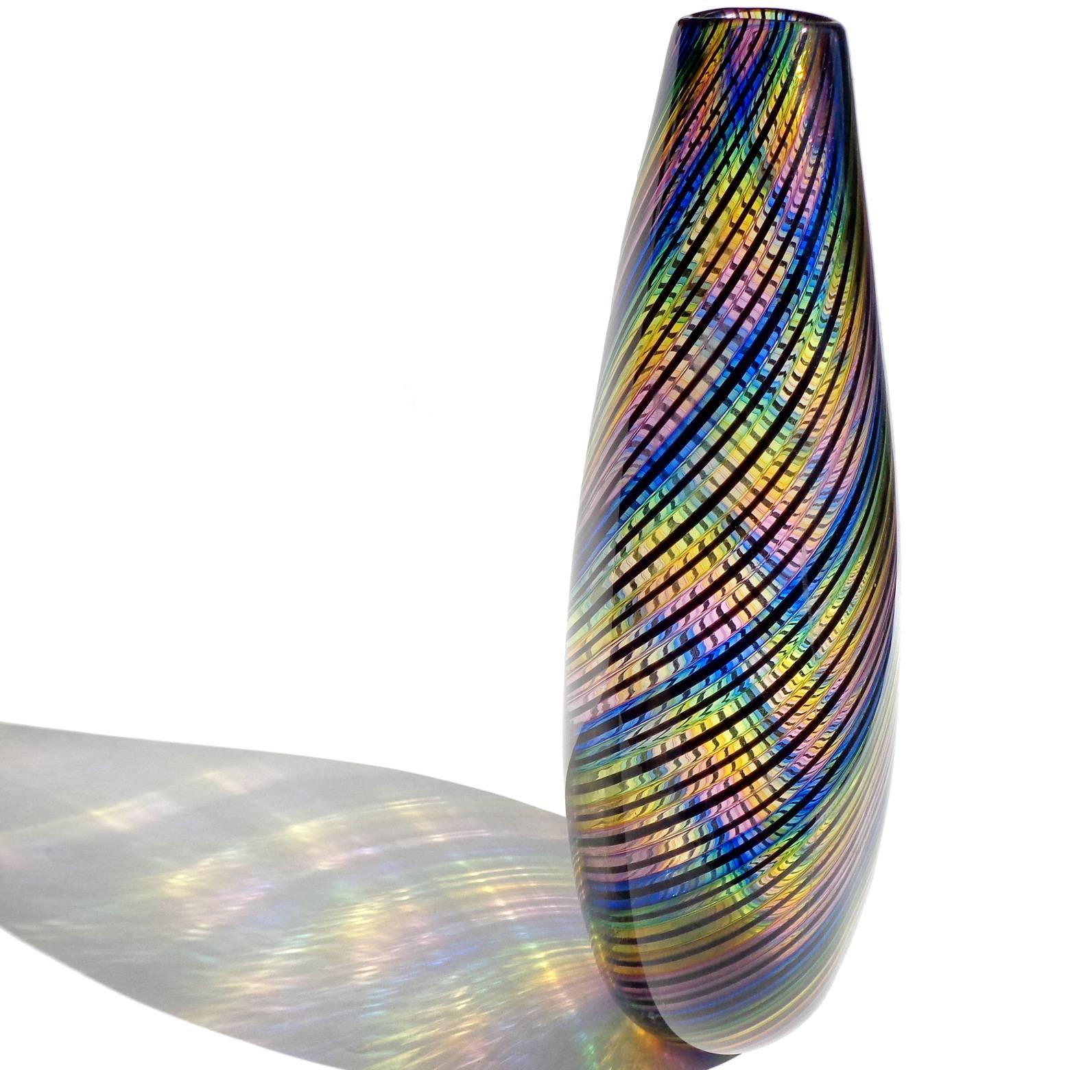 Gorgeous art glass rainbow colors ribbons flower vase. Has blue, green, yellow, pink and black colors. The piece is stamped underneath "SOLA". In the manner of Murano Italy glass. Unsure of age, but believe it is a modern piece. Stunning!
