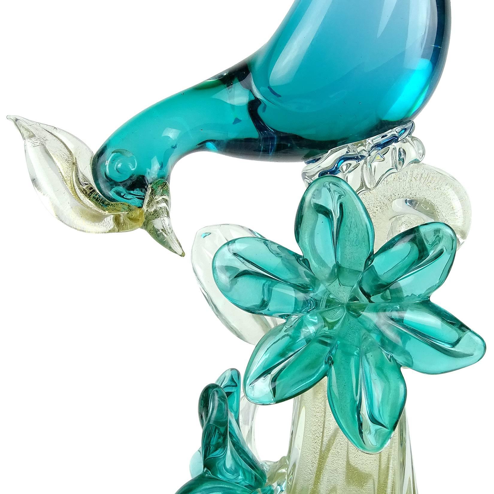 Elegant large Murano handblown aqua blue green Sommerso and gold flecks Italian art glass bird of paradise / pheasants sculpture. Documented to Alfredo Barbini, circa 1950s. The bird is perched on a gold flecked branch with 2 flowers attached. A
