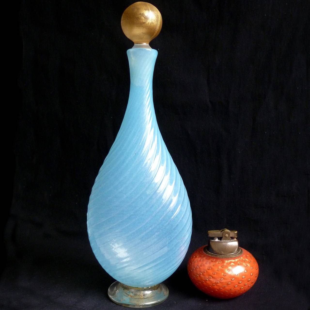Gorgeous Murano handblown opal blue and gold flecks Italian art glass decanter with gold stopper. Created in the manner of designers Ercole Barovier and Alfredo Barbini. The piece has a slight ribbed pattern to the body, and an applied foot with