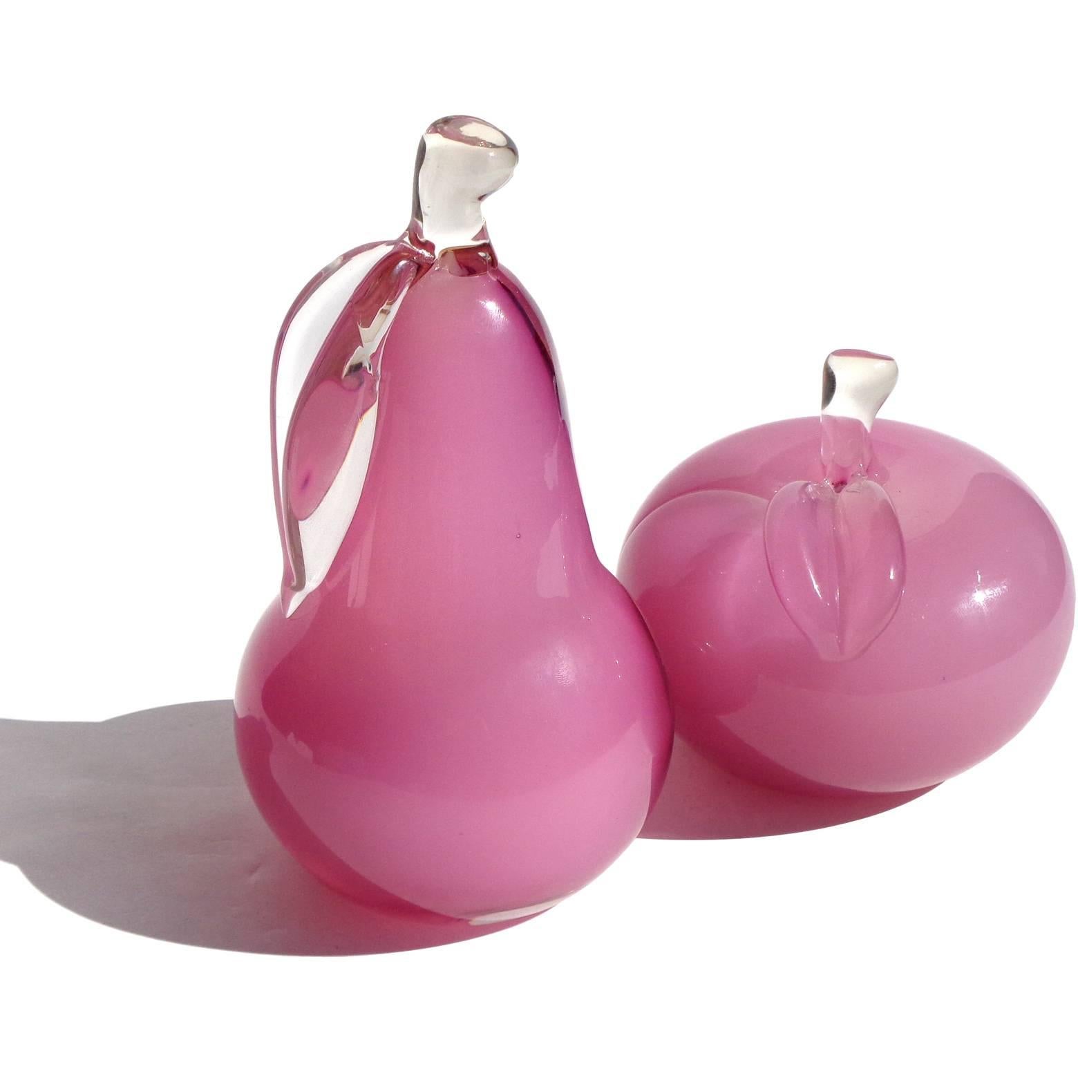 Gorgeous set of Murano handblown opal pink over white Italian art glass pear and apple sculptures. They are not bookends, but decorative pieces. In the manner of Archimede Seguso. The pear is 6 1/2 inches tall, apple 3 3/4 tall.
      