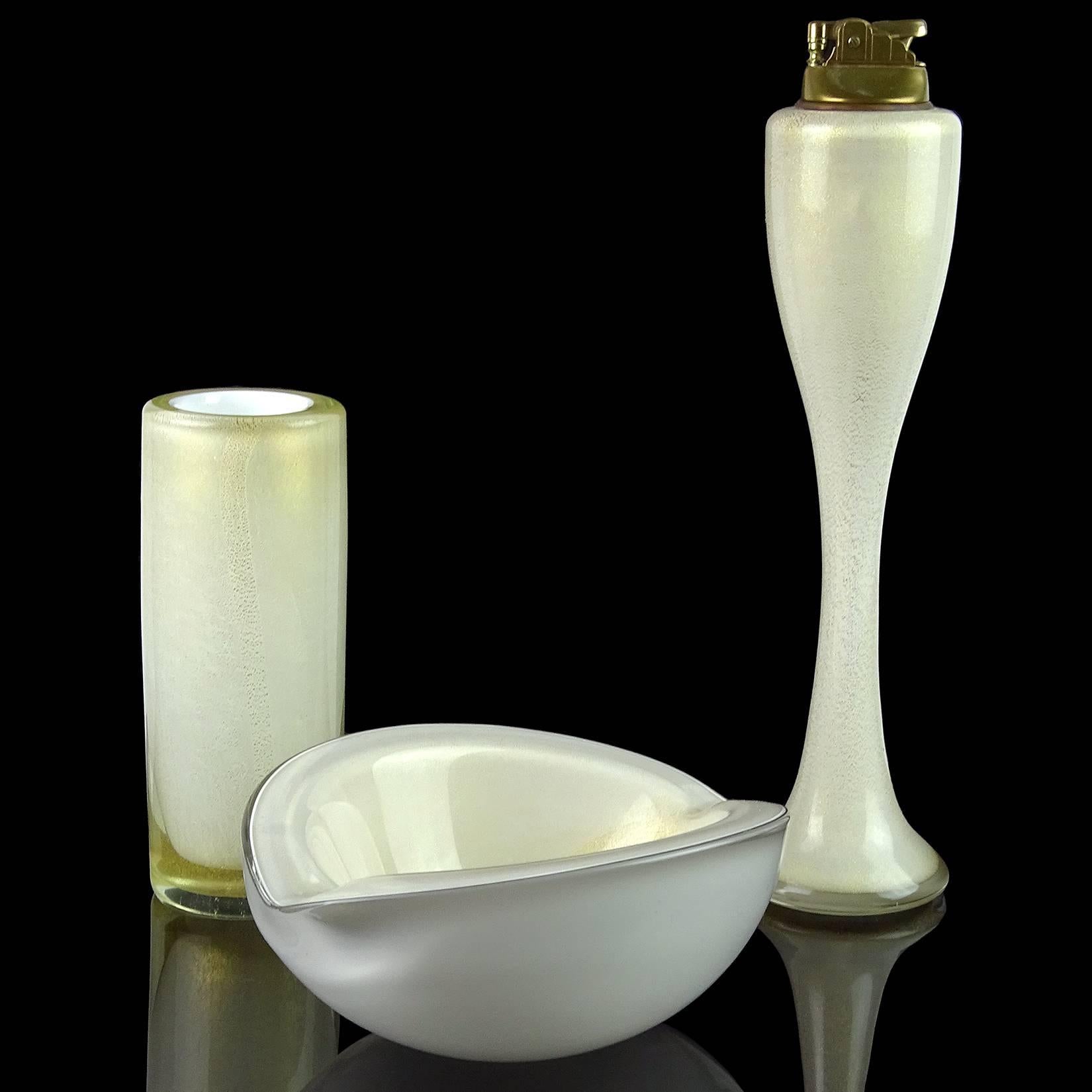 Beautiful Murano handblown pure white with gold flecks art glass bowl, flower vase, and tall lighter set. Documented to designer Alfredo Barbini, circa 1950s-1960s. All three pieces are profusely covered in gold leaf. The tall lighter, in rare size
