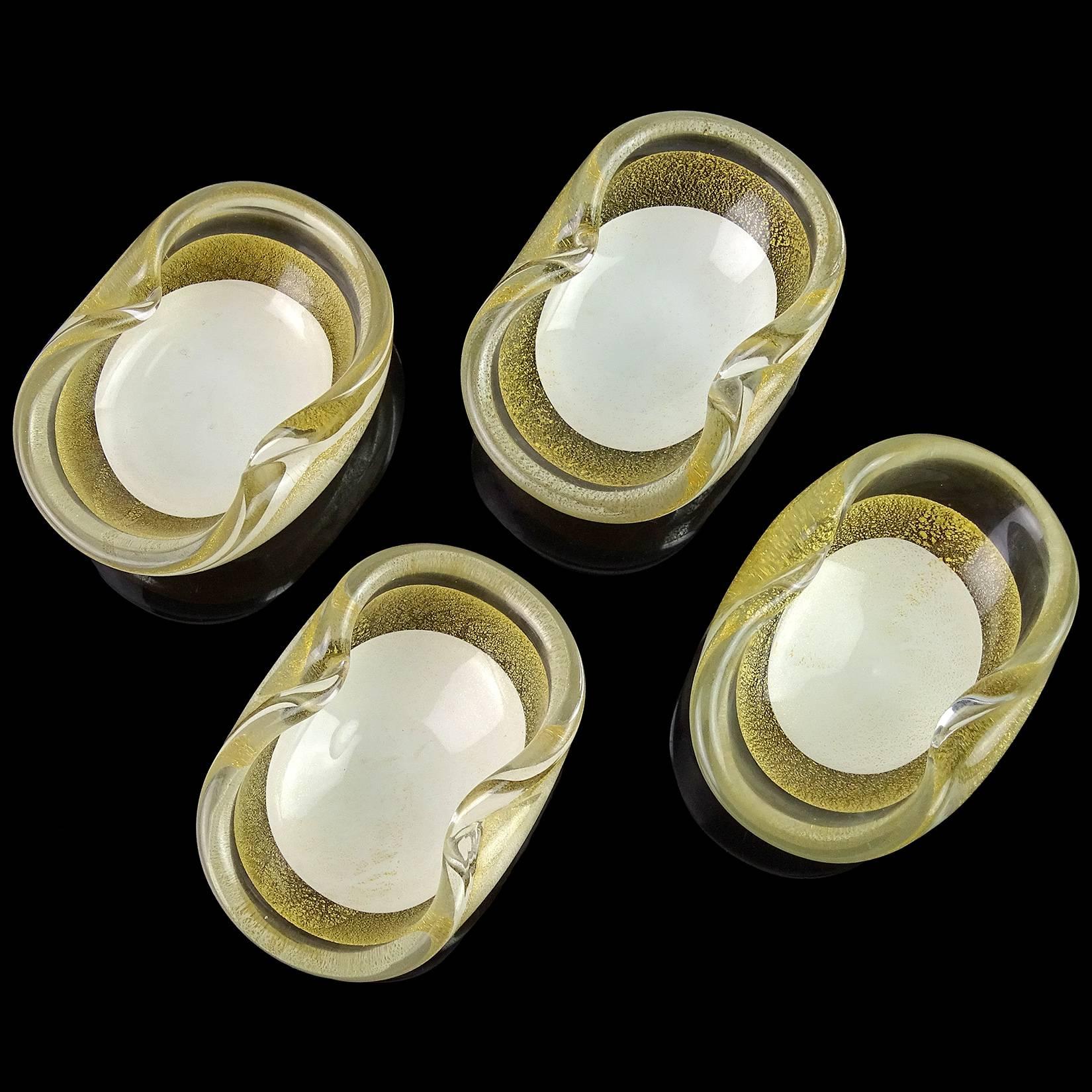Beautiful set of Murano handblown gold flecks over white Italian art glass ring bowls or salt dishes. Documented to the Salviati Company, circa 1950s. Simple and elegant shapes. Covered throughout with gold leaf. They measure about 3 3/8” long x 2