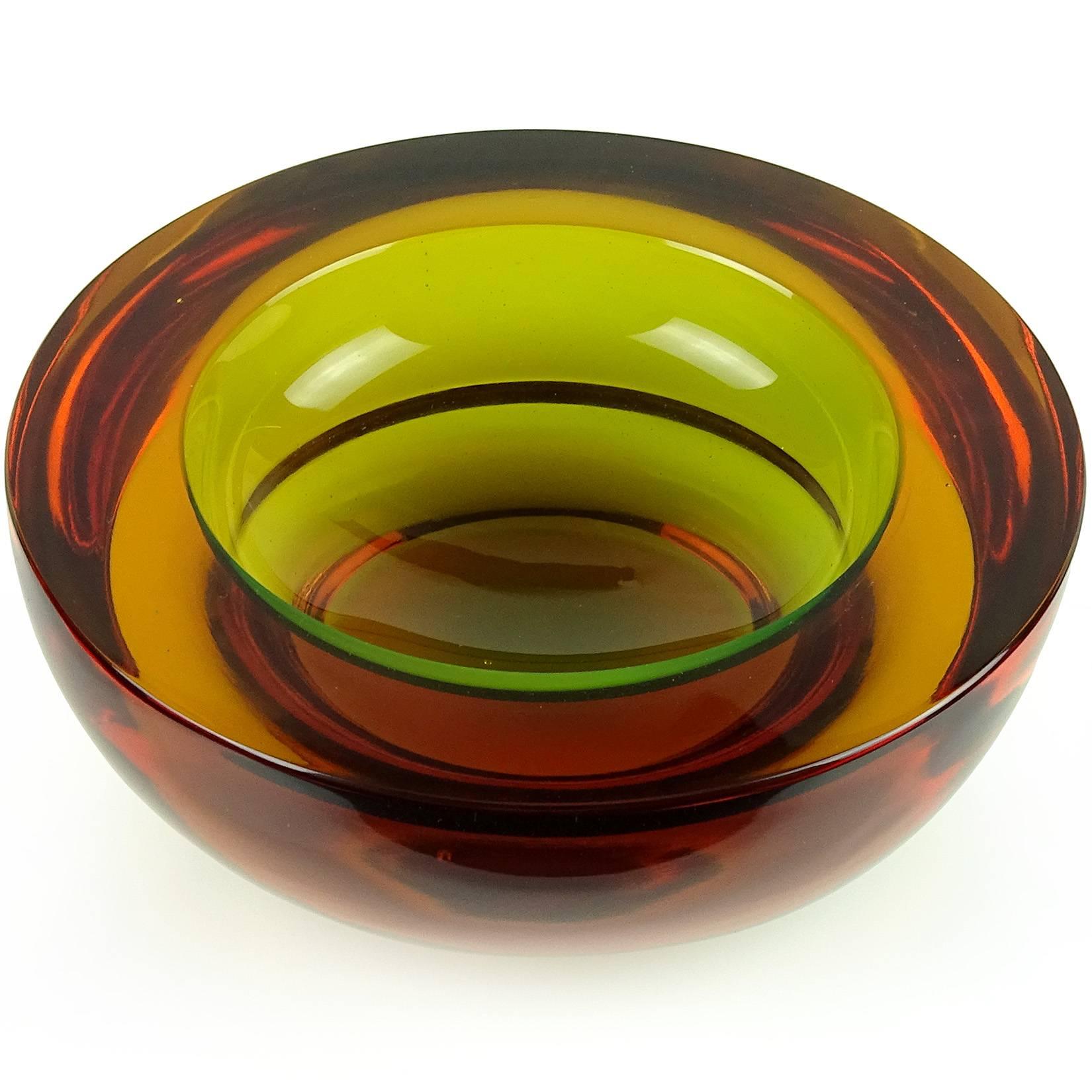 Beautiful Murano hand blown Sommerso amber red and green Italian art glass bowl. Documented to designer Flavio Poli, for the Seguso Vetri d'Arte company. The piece is very thick and heavy, raised by a sculpted foot, and flat cut rim. Measures 6 1/4”