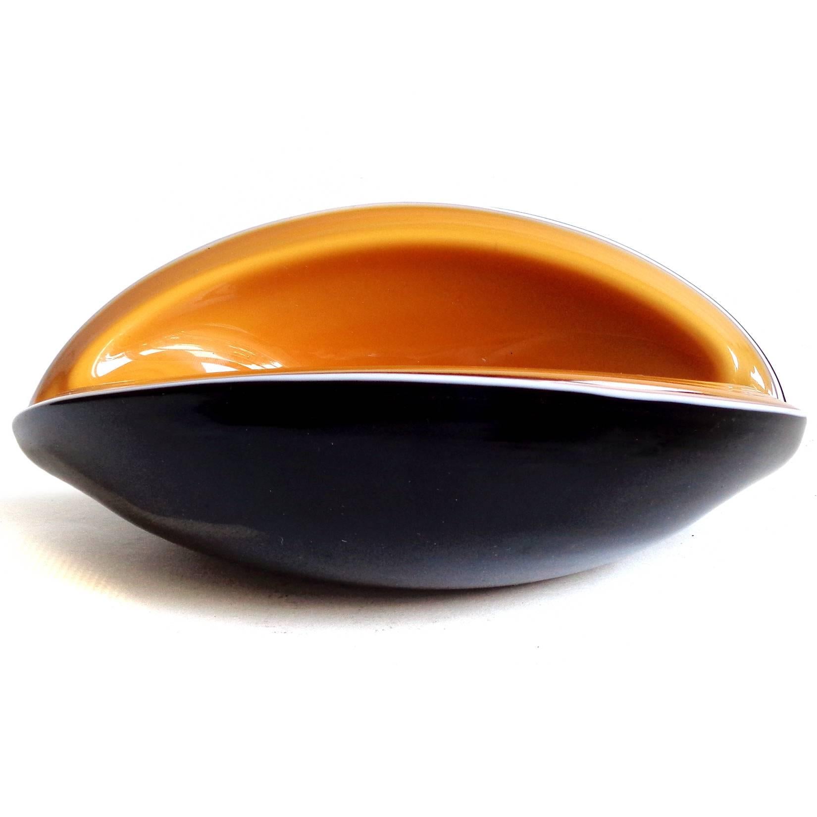 Free shipping worldwide! See details below description.

Striking Murano handblown black over white, and pumpkin orange art glass melon cut bowl. Documented to designer Alfredo Barbini. The bowl is cut at an angle on both sides, with small indents