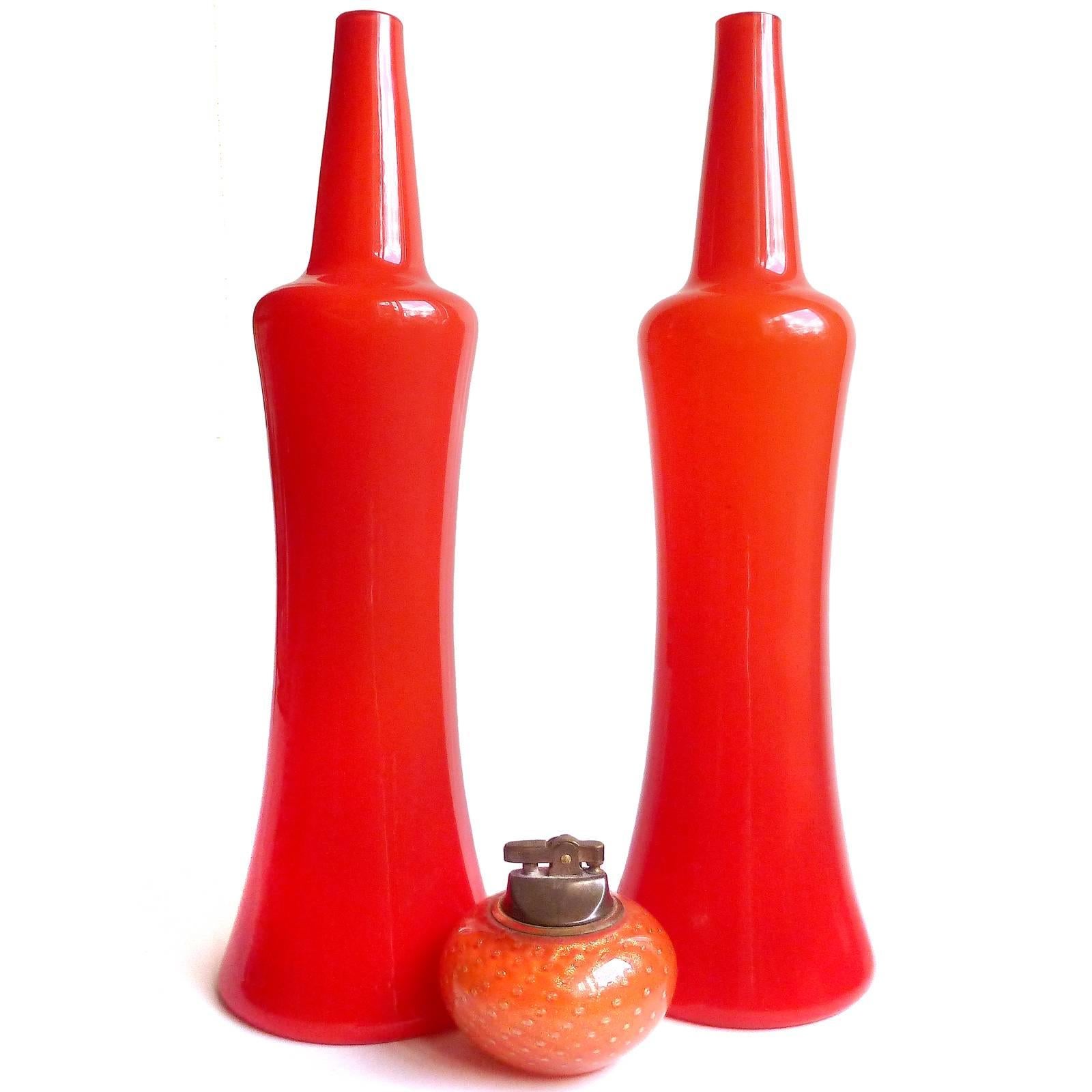 Large pair of Murano hand blown red over white Italian art glass rocket shaped flower vases with original labels. Documented to the Fratelli Toso company, with "Murano Glass - Made in Italy" labels underneath each of them. Could be turned