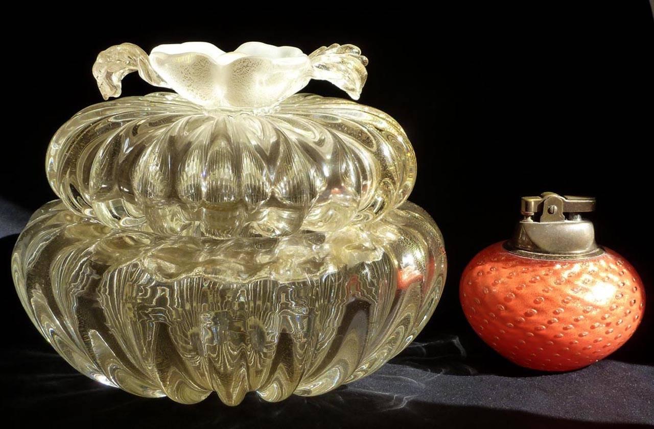 Free shipping worldwide! See details below description.

Elegant Murano handblown gold flecks with applied white flower art glass vanity jewelry / powder box. Attributed to designer Archimede Seguso. This is an oversize piece, in a ribbed pattern.