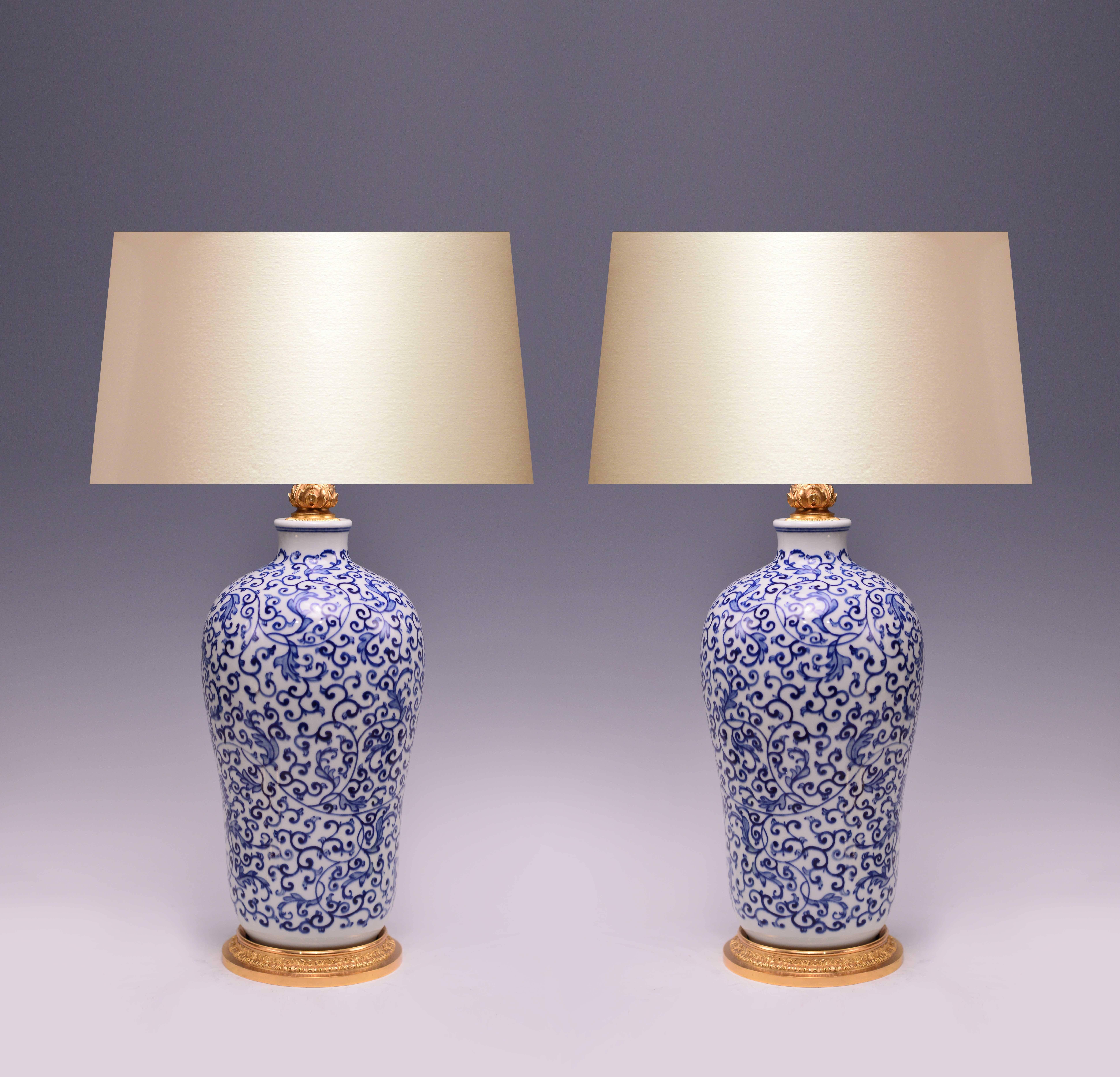 Pair of finely painted blue and white porcelain lamps with floral scroll decoration, gilt brass bases.
Measures: To the porcelain 16.5 inch H.
(Lampshade not included).