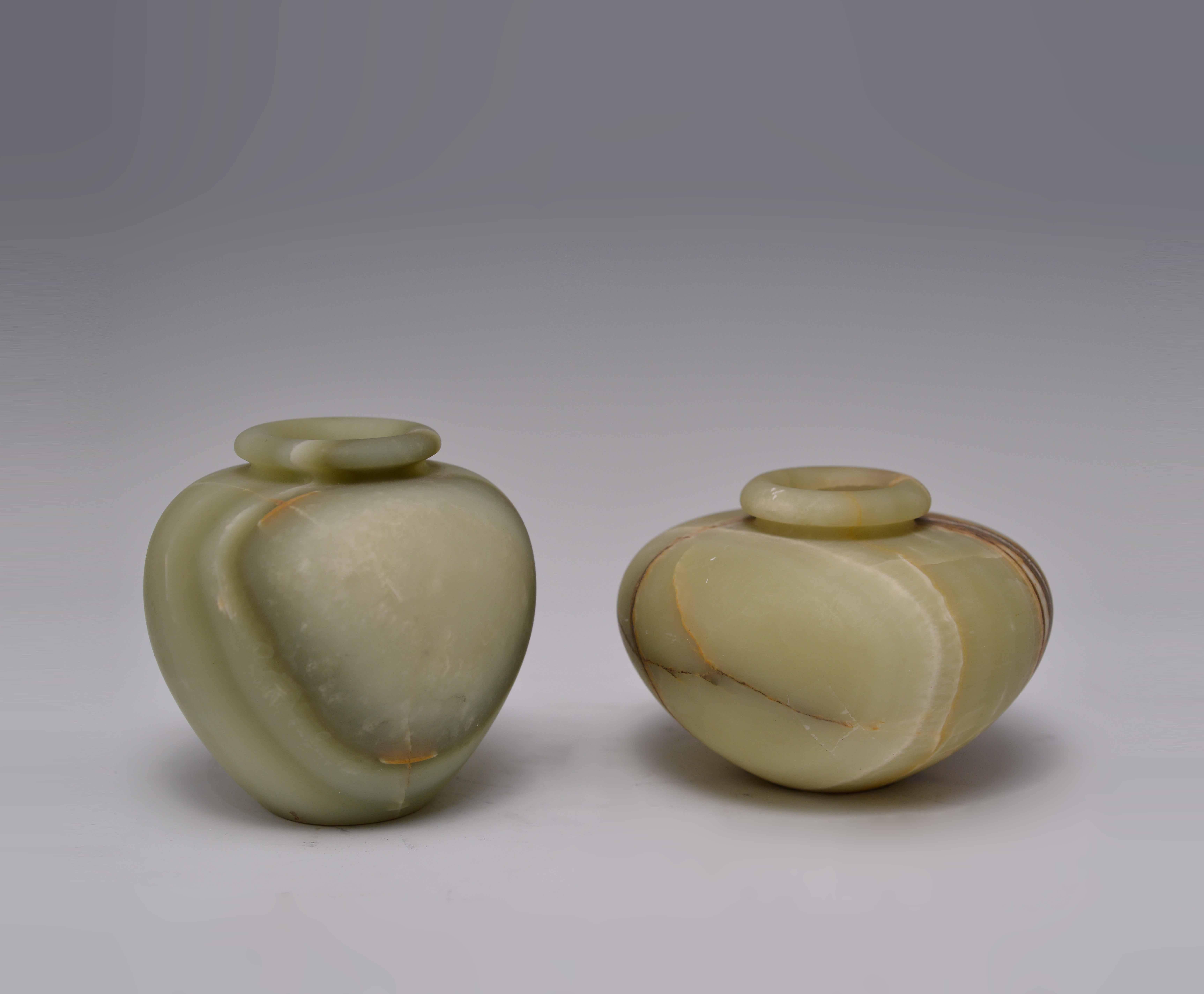Group of two carved celadon jade baluster jars with beautiful jade veins cross the body.
Measures: Left: 7 in. H x 5 in. W
Right: 6 in. H x 6 in. W.