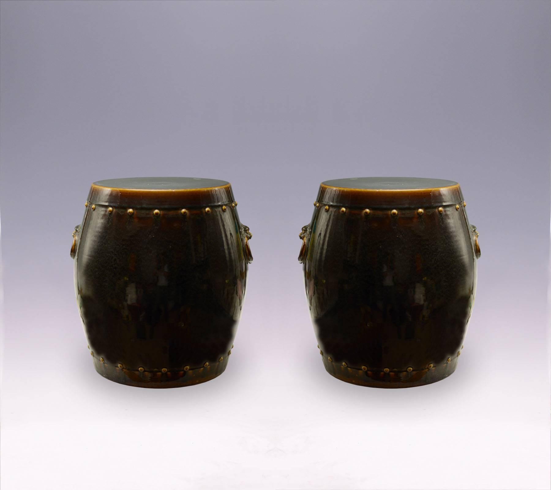 A pair of brown porcelain stools in a simple oval form body that fading from light to dark in a glaze surface. The design on the top and base each merged with a circular yellowish ring. circa 1920.

