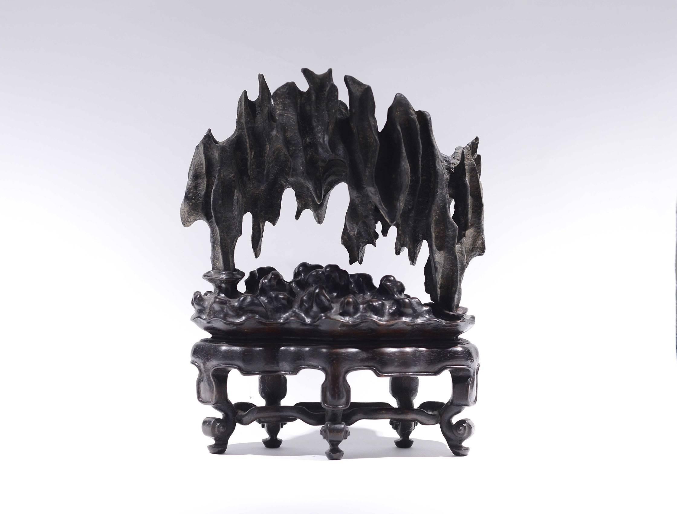 A lingbi scholar's rock in the form of a stone bridge with fine carved hardwood stand, created by Phoenix Gallery, New York City.