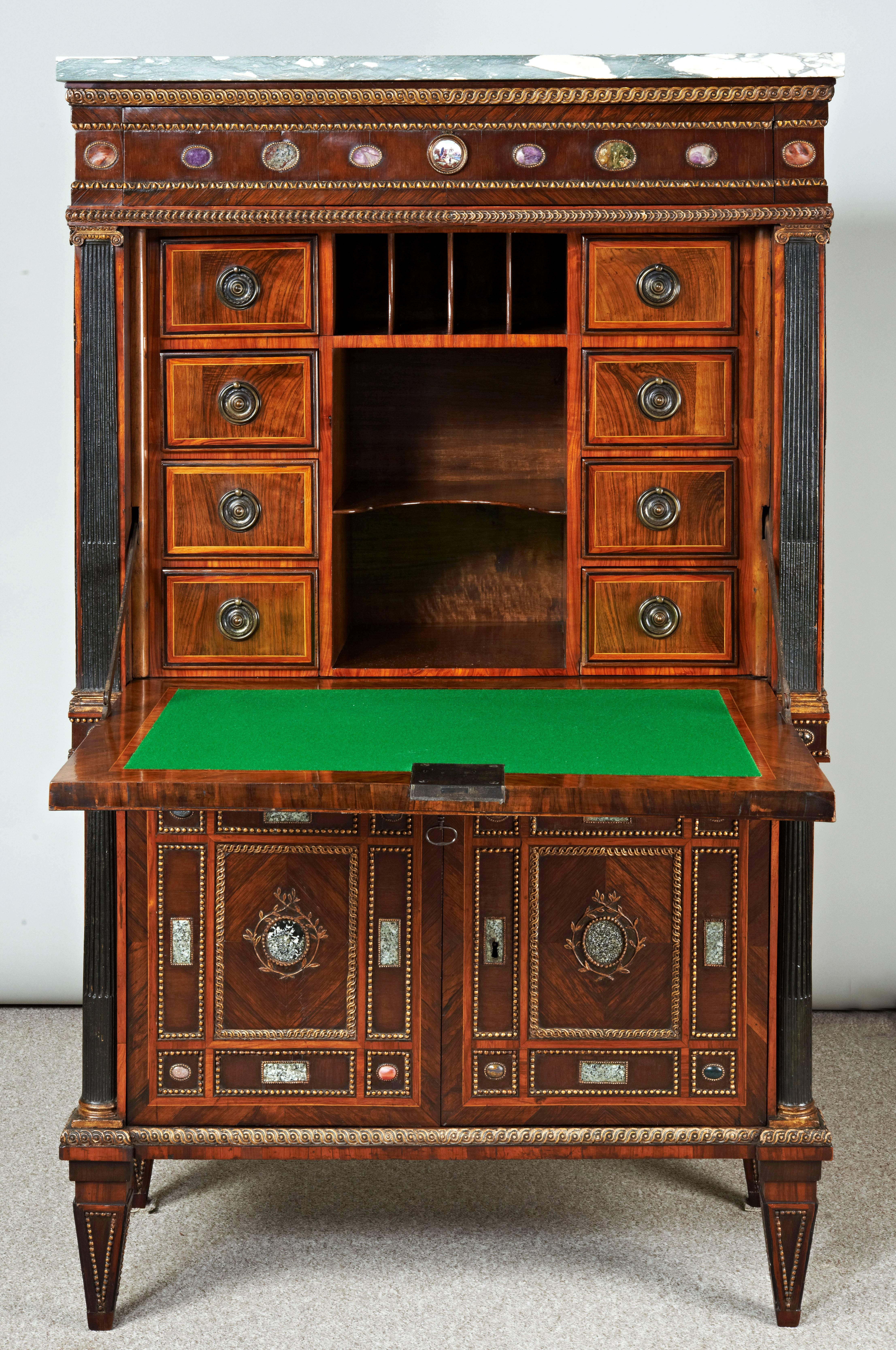 A very rare North Italian secretaire cabinet with a breccia verde marble top, a frieze drawer set with eight hardstone specimens, the fall front with a central oval green porphyry panel surrounded by hardstone and marble specimens on a purple heart