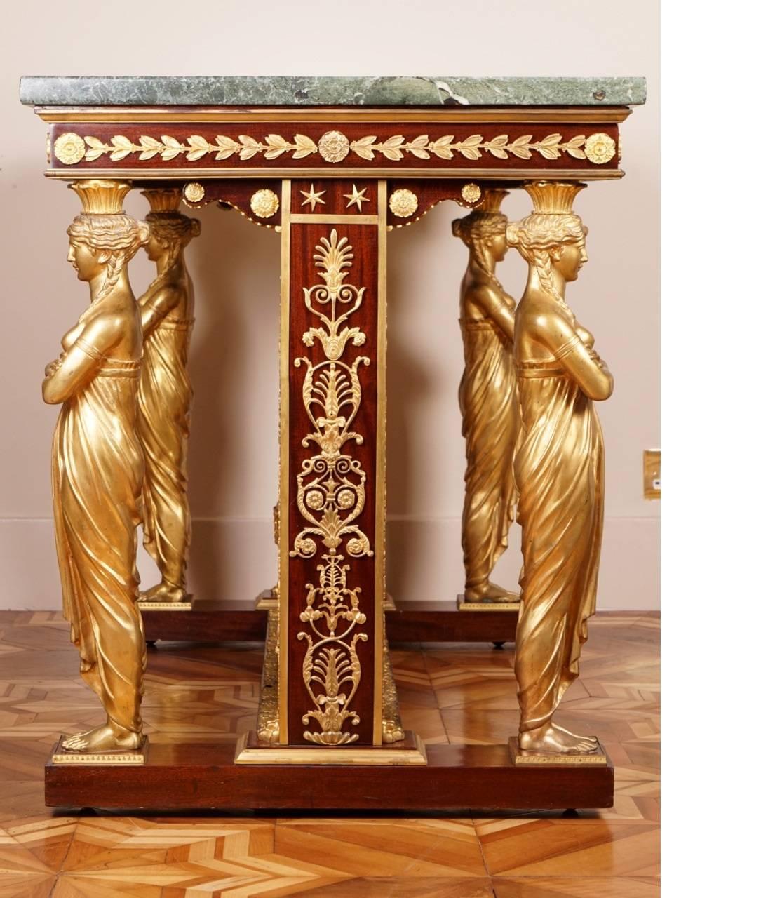 
The Empire style ormolu-mounted mahogany centre table with a vert maurin marble top with moulded lip, above a frieze with trailing-leaf and rosette mounts, on caryatid supports and mahogany uprights with applied mounts and joined by a stretcher