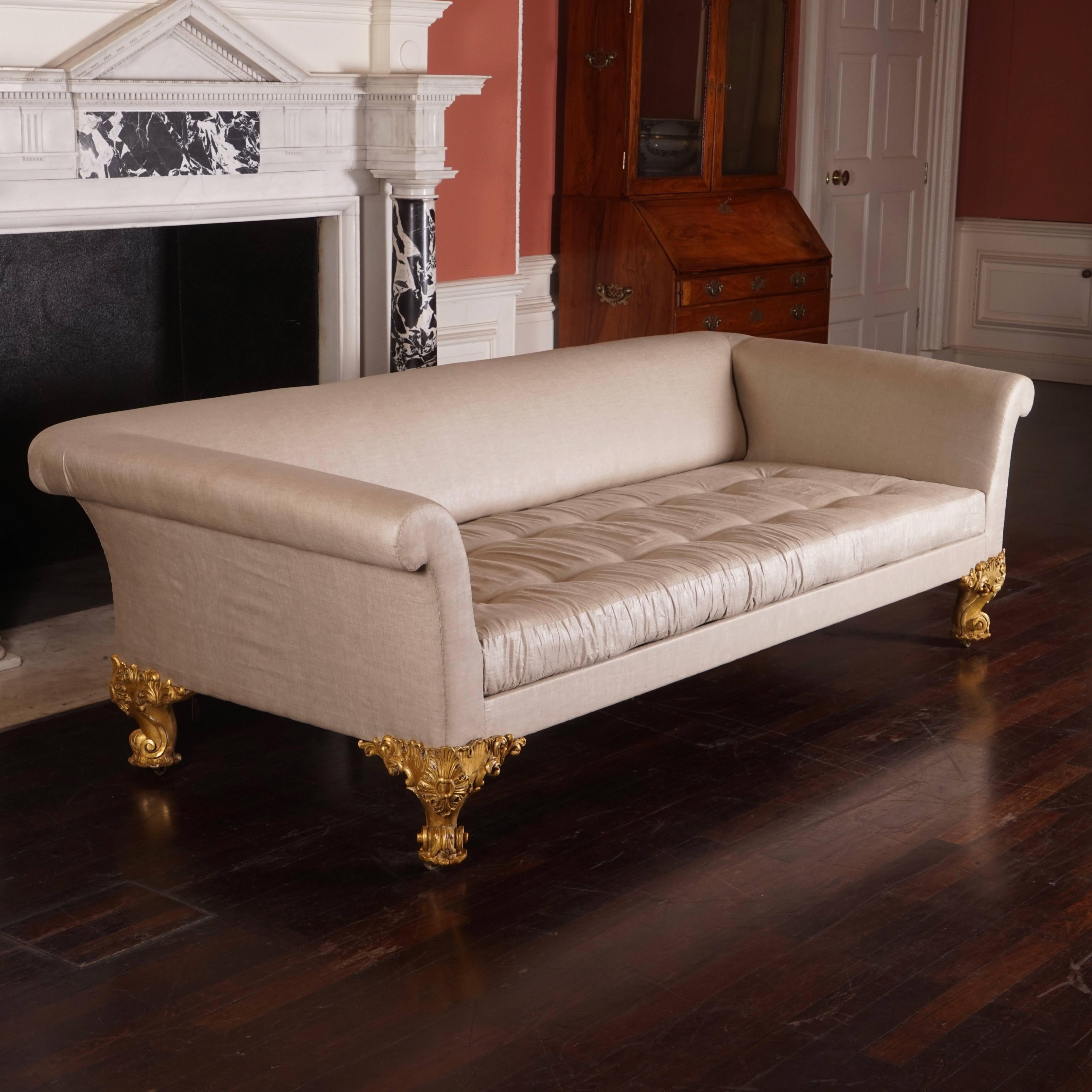 The sofa of country house proportions with particularly well carved foliate giltwood feet. Reupholstered in a glazed linen.