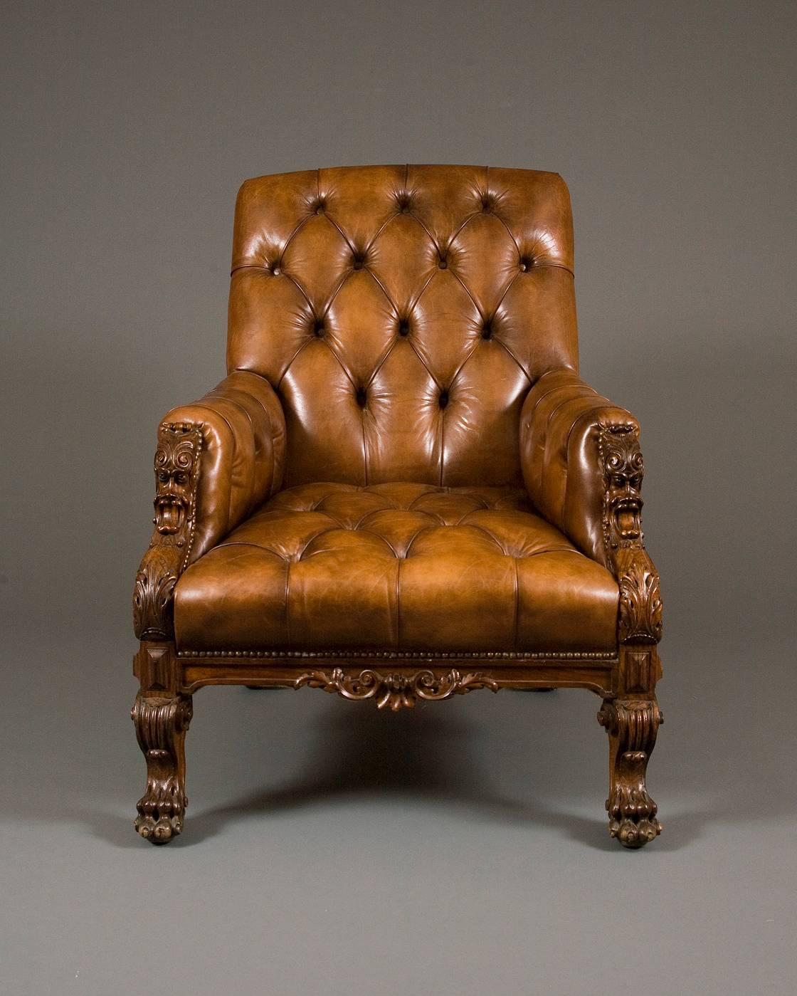 Having deep buttoned tan leather upholstered back, seat and enclosed arms.
The front supports extensively carved, each with an acanthus scroll above a grotesque mask leading to further acanthus and reeded scrolls, terminating in claw feet.
The