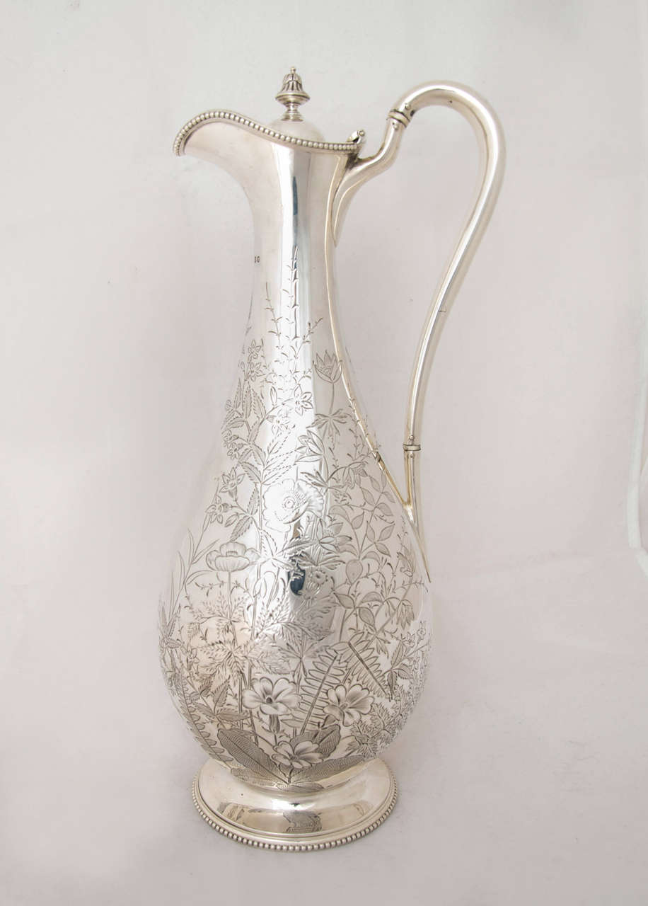 An antique Victorian silver wine jug engraved with leaves and foliage.
Made by Henry Atkin of Sheffield, 1883.
Measures: Height is 34 cm.