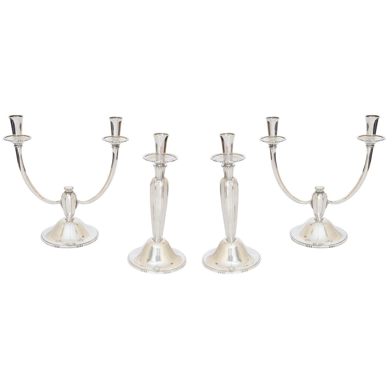 A rare and important Modernist candelabra suite comprising a pair of candlesticks and a pair of candelabra. The suite was made by the renowned silversmith Robert Edgar Stone (1903-1990) and retailed by the Royal Goldsmith & Silversmith, Garrard &