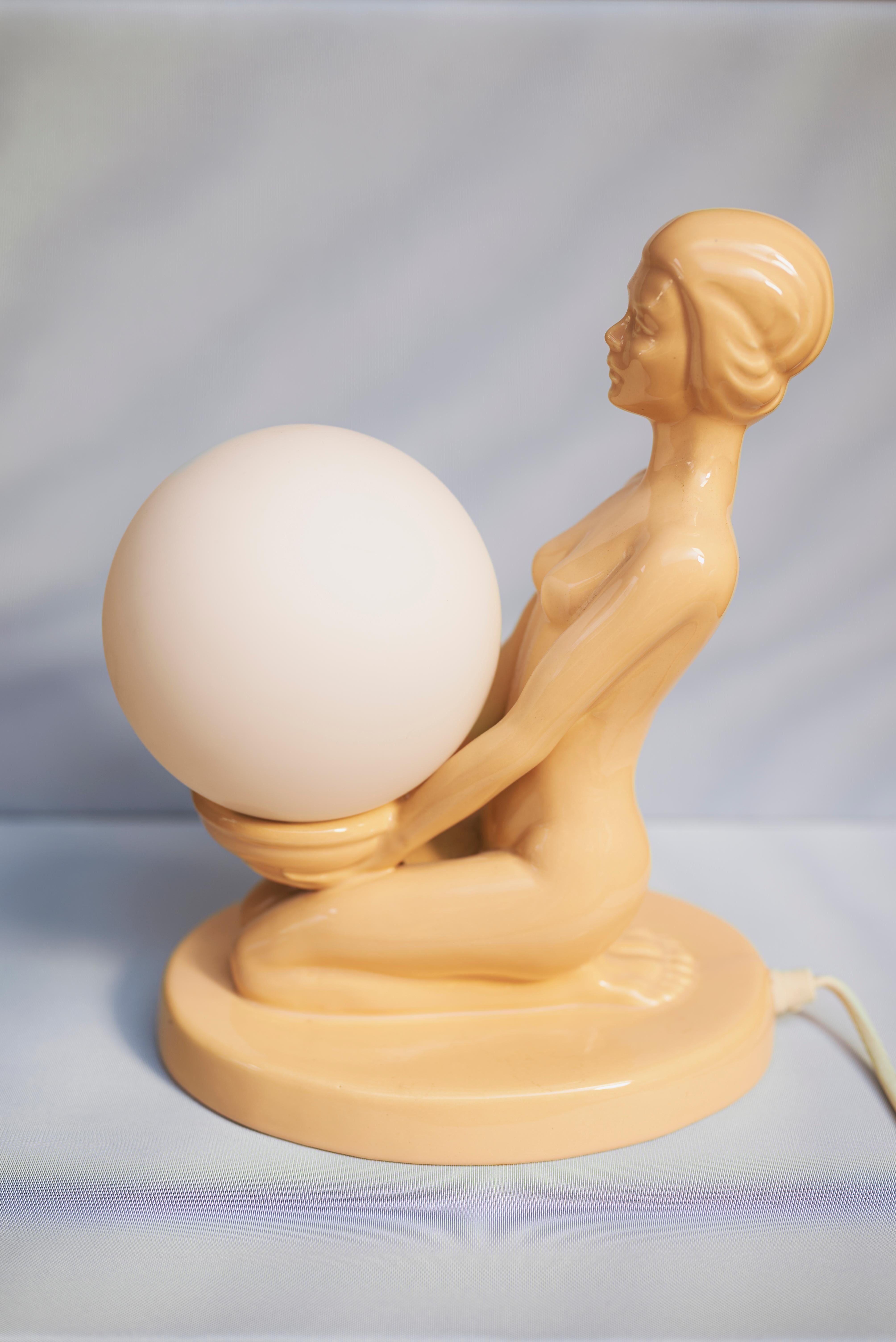 Lampe de table femme en céramique rose tendre avec globe en verre opalin, Europe, 1970

Élégante et rare lampe de table sculpturale du milieu du siècle dernier, représentant une figure féminine en céramique à la glaçure rose tendre et délicate.