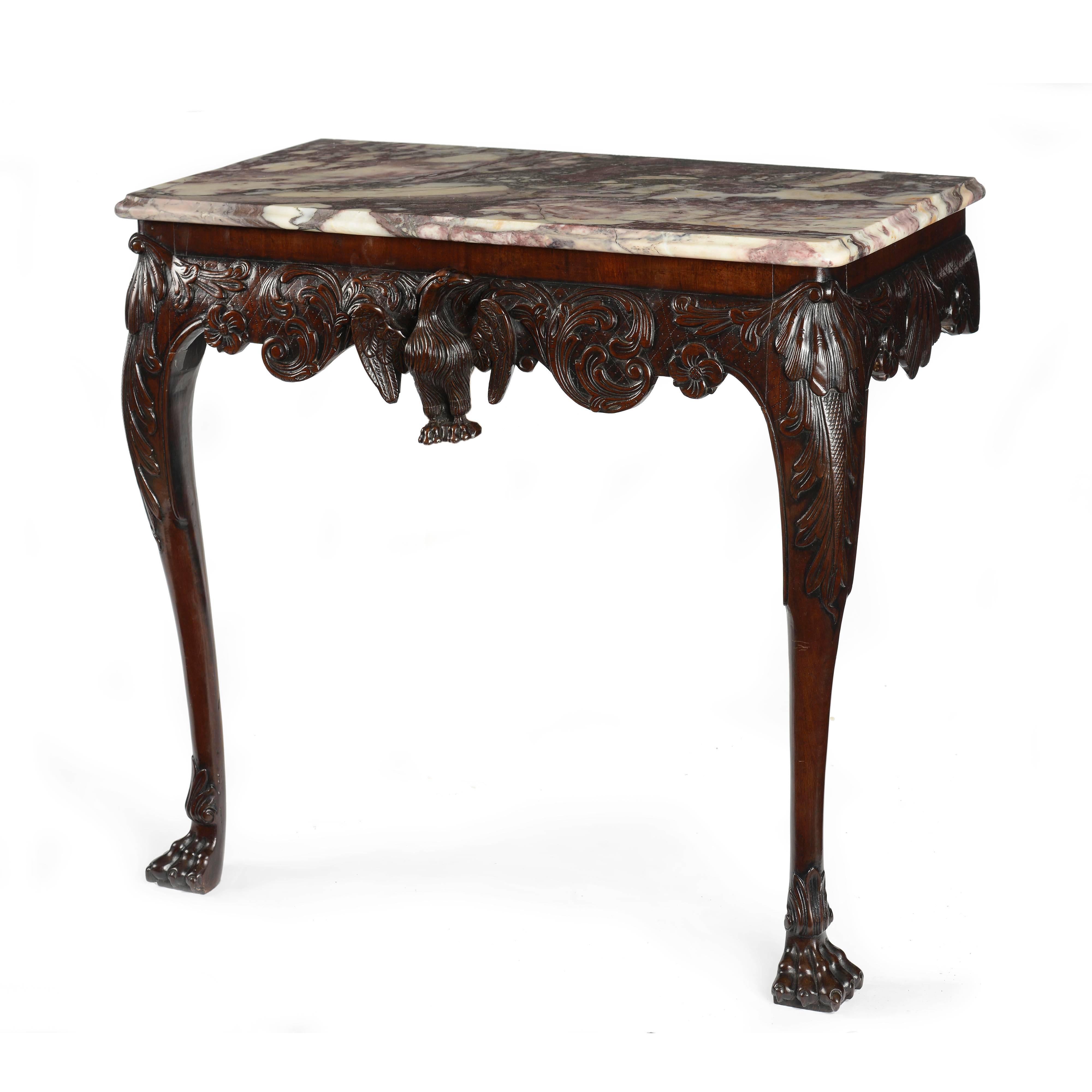 A superb Irish George II carved Cuban mahogany console table, with crisply carved detailing and excellent color and patina throughout. The breche Violette moulded marble top of rectangular form with moulded edge, below a central carved spread eagle