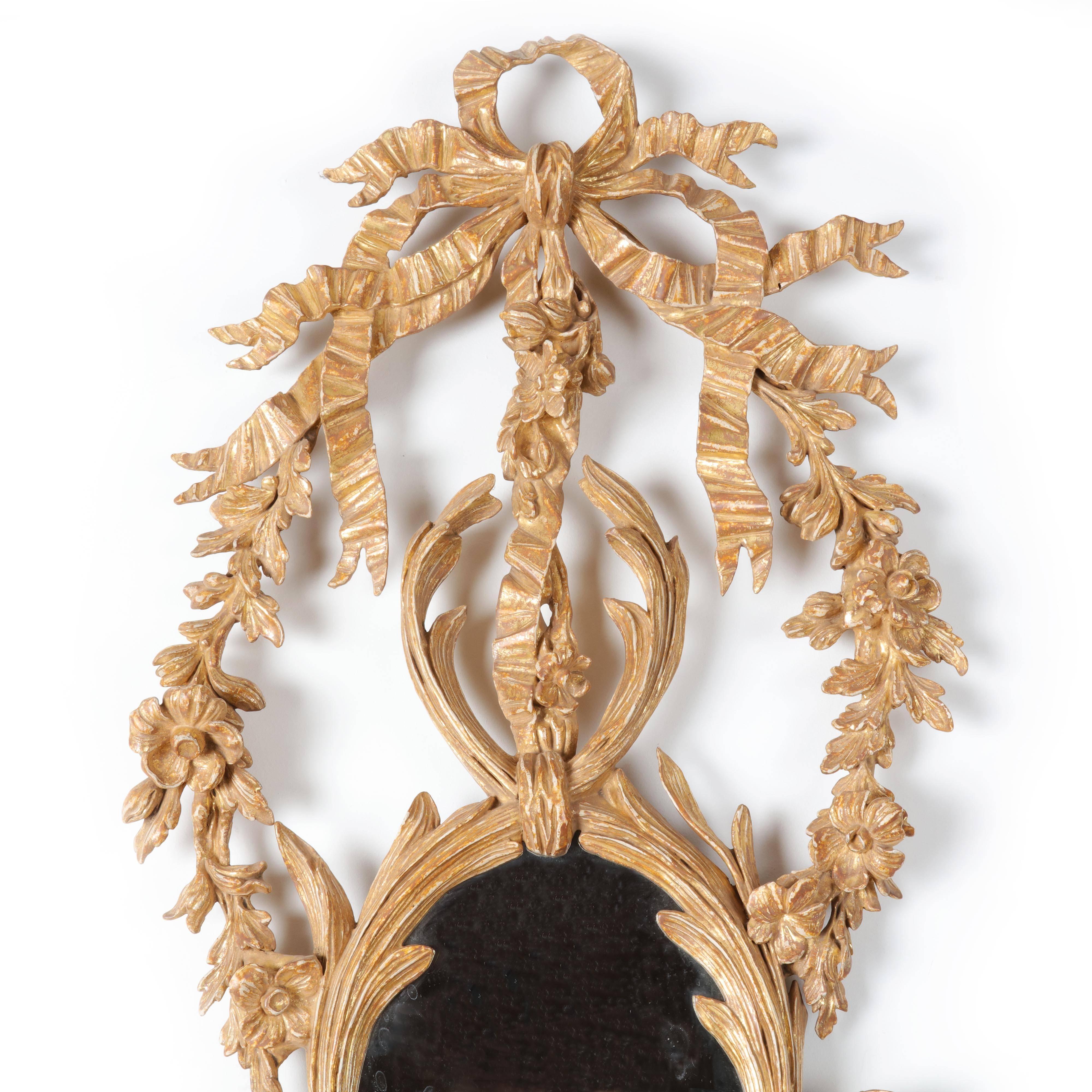 A tall exquisitely detailed and beautifully carved George III giltwood girandole mirror attributed to John Linnell. The frame elaborately carved with leaves, ribbons and leaf work foliage formed around two oval plates and a pediment with elaborate