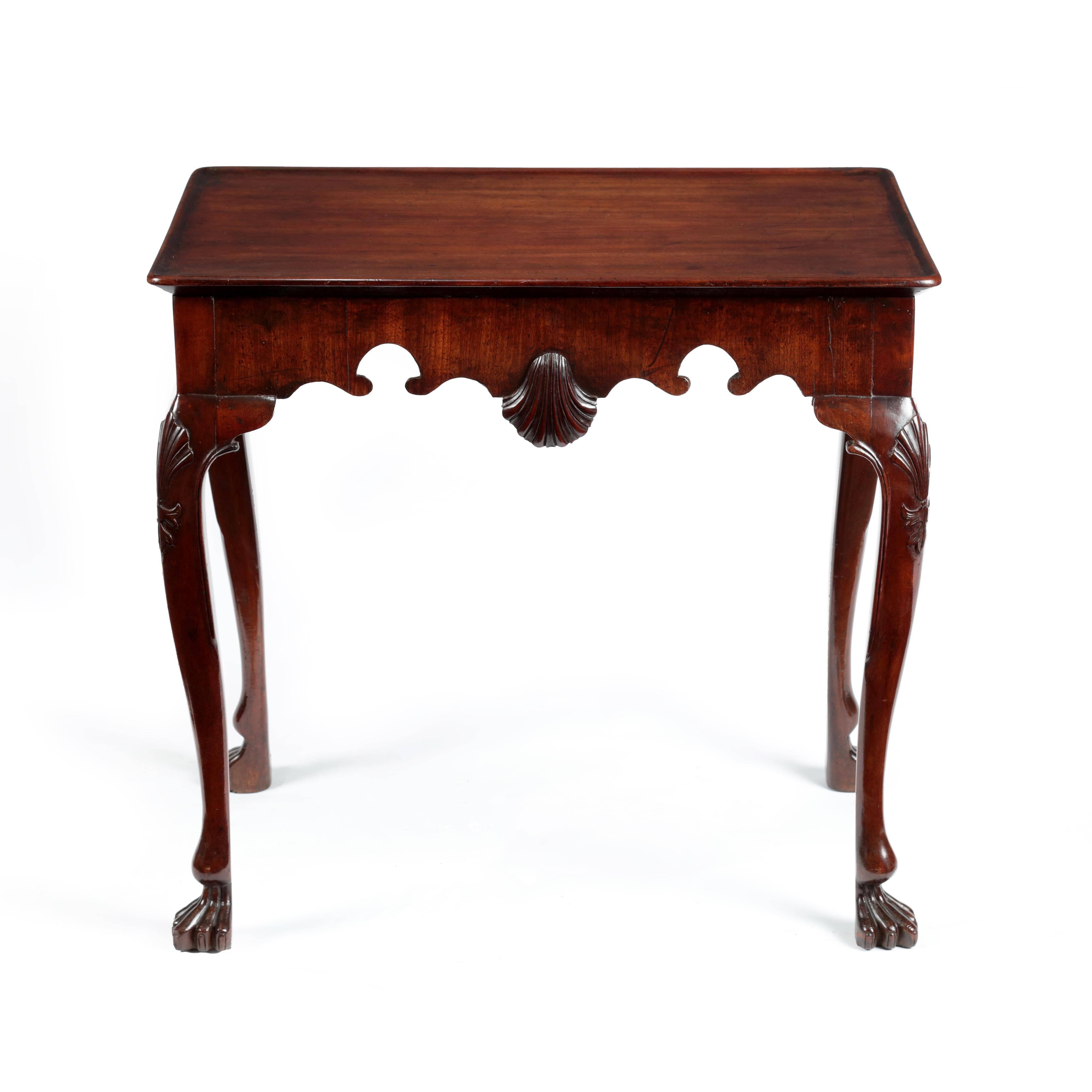 A Fine George II Irish Cuban mahogany tray top silver table of compact dimensions. The rectangular top with rounded corners and moulded lip to the edge, over a frieze with scroll cut apron and carved shell to the centre. The table is supported by