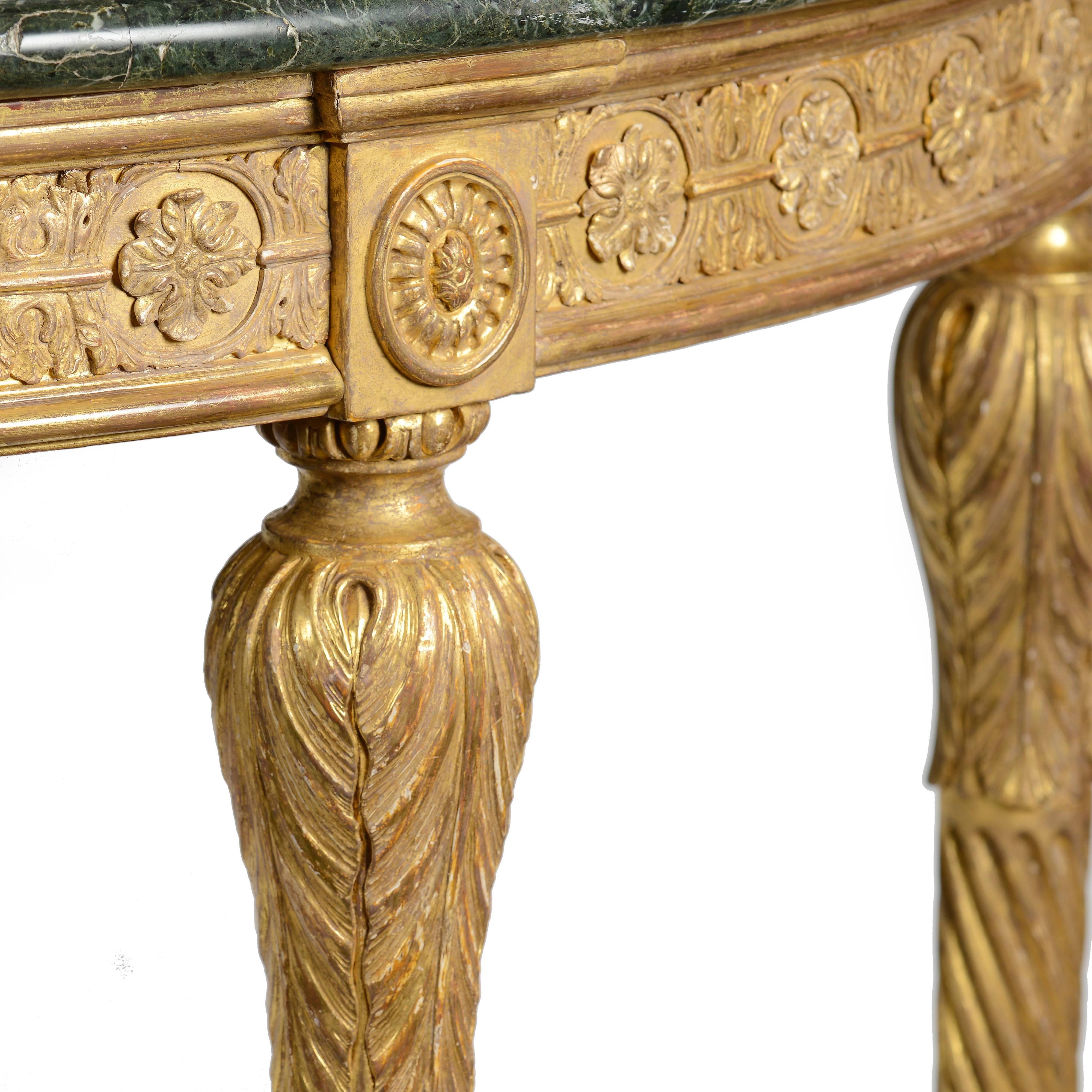 Description: A fine George III Adam period carved giltwood demi-lune pier table. The carved frieze with alternating flower rosettes inset into an acanthus leaf chain, bordered top and bottom by ovolo and demi-lune mouldings. The legs of turned