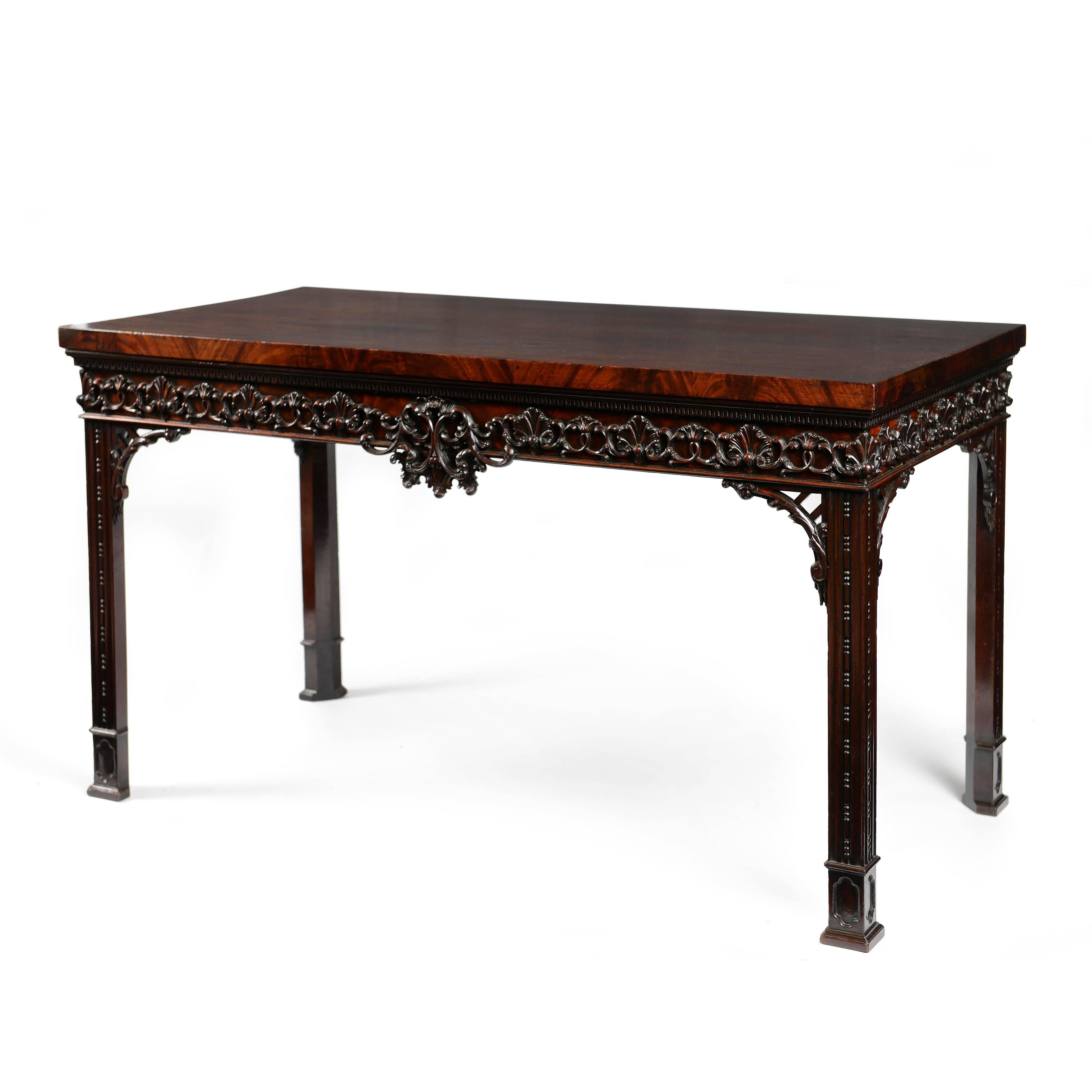An important, excellently proportioned George II carved mahogany side table, in the manner of Thomas Chippendale, retaining excellent original color and patina. The top constructed of well-chosen figured veneers, on a solid mahogany base with banded