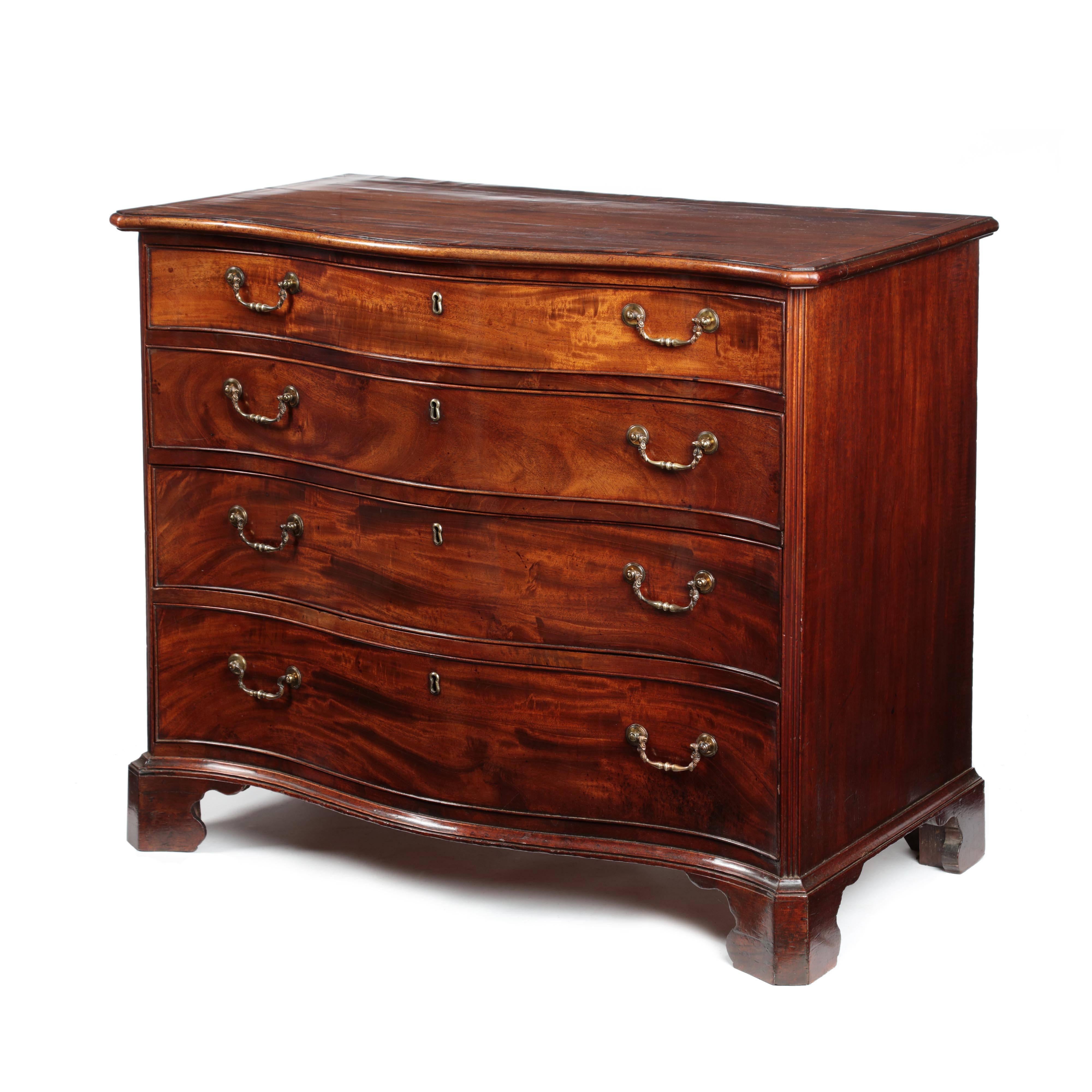 A fine early George III figured mahogany serpentine fronted chest of compact dimensions and of excellent original color and patina. The serpentine fronted top of elegant, cross-banded in flame mahogany with fronted canted corners and a moulded edge.