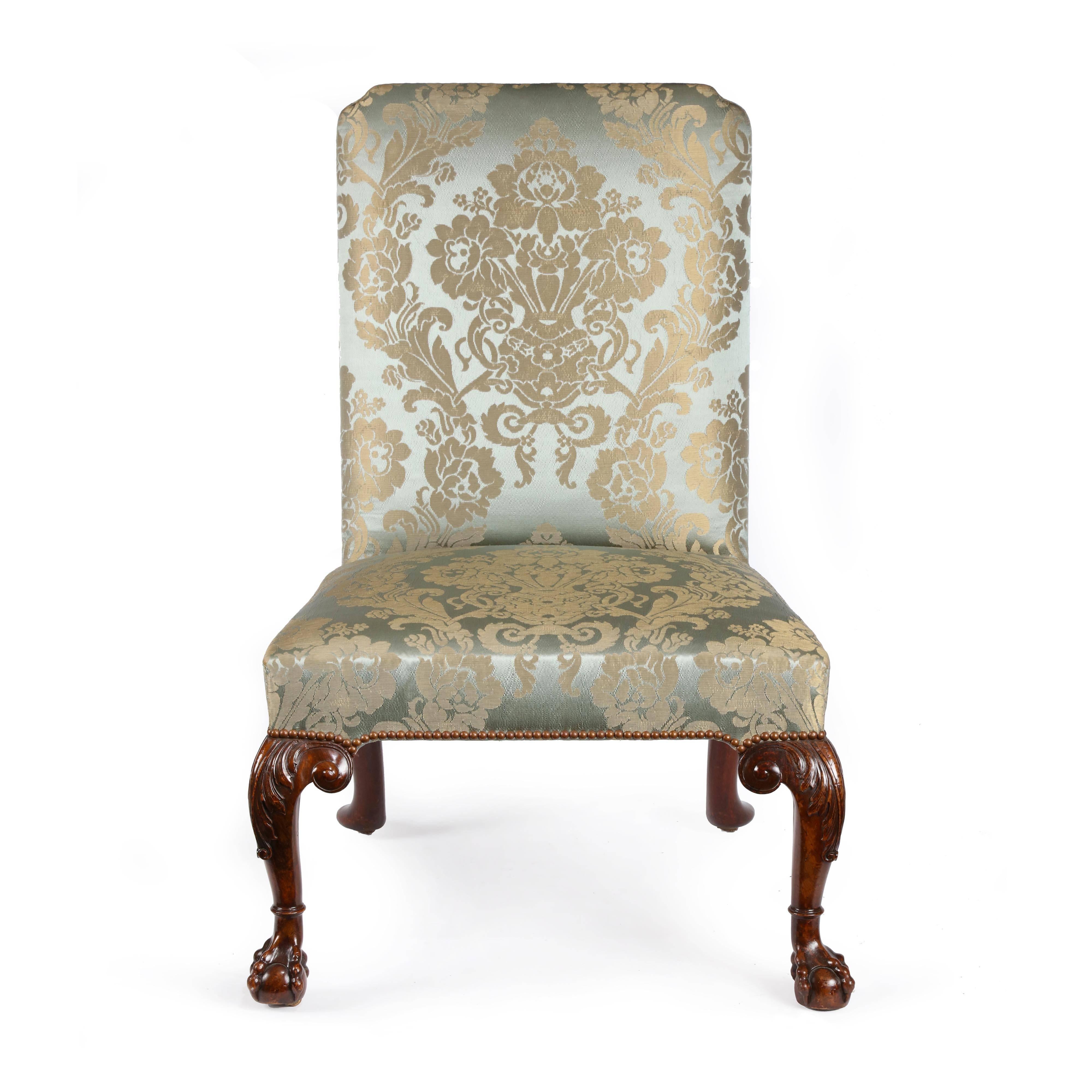 A fine pair of George II carved walnut side chairs attributed to William Hallett. The rectangular shaped silk damask upholstered backs with top curved re-entrant corners, The seat section of square tapering section, with upholstery close nailed