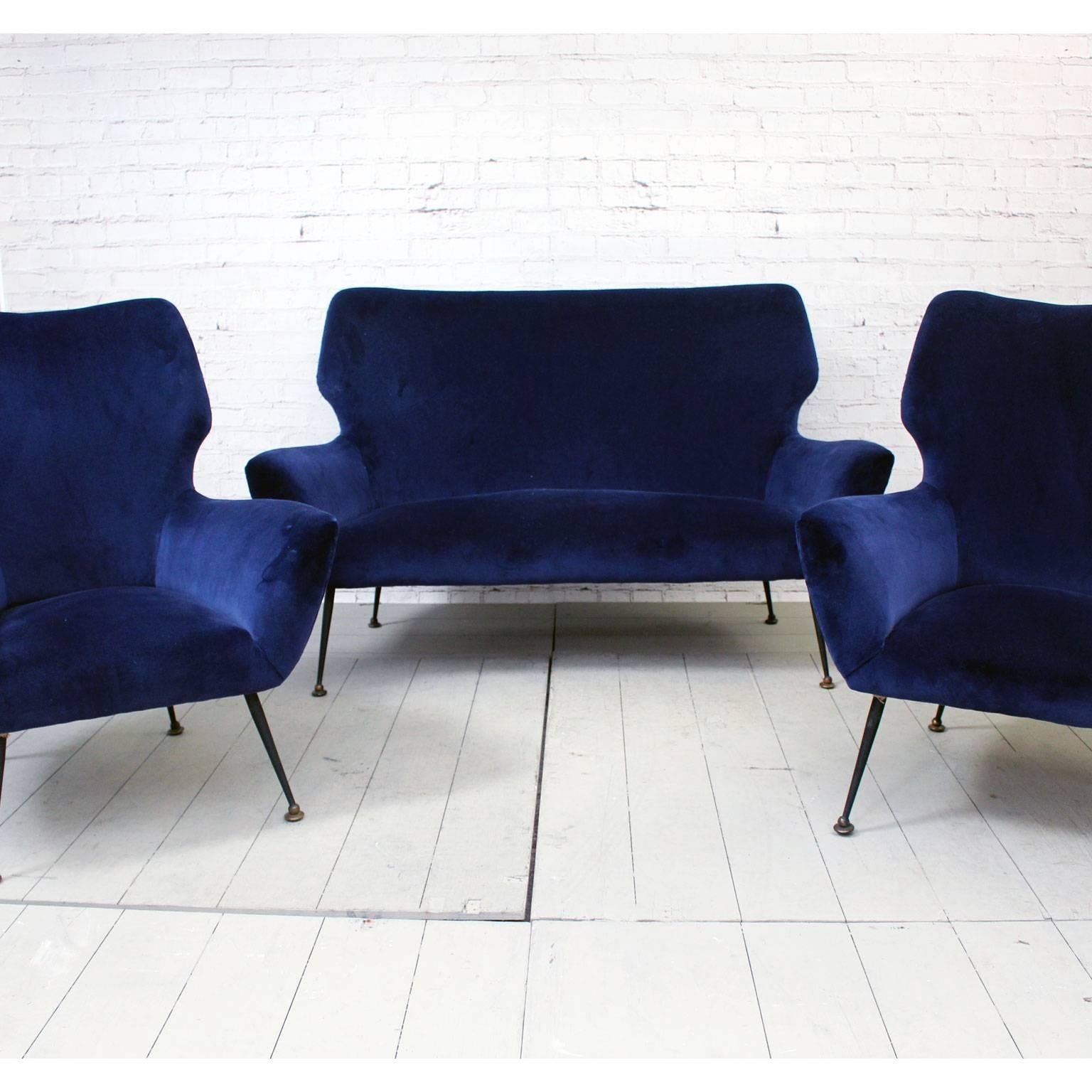 This super stylish pair of Italian armchairs is of the highest quality. We love the design and especially their splayed black legs on brass feet and unusual shape. These chairs were originally part of a suite, we therefore have a matching sofa