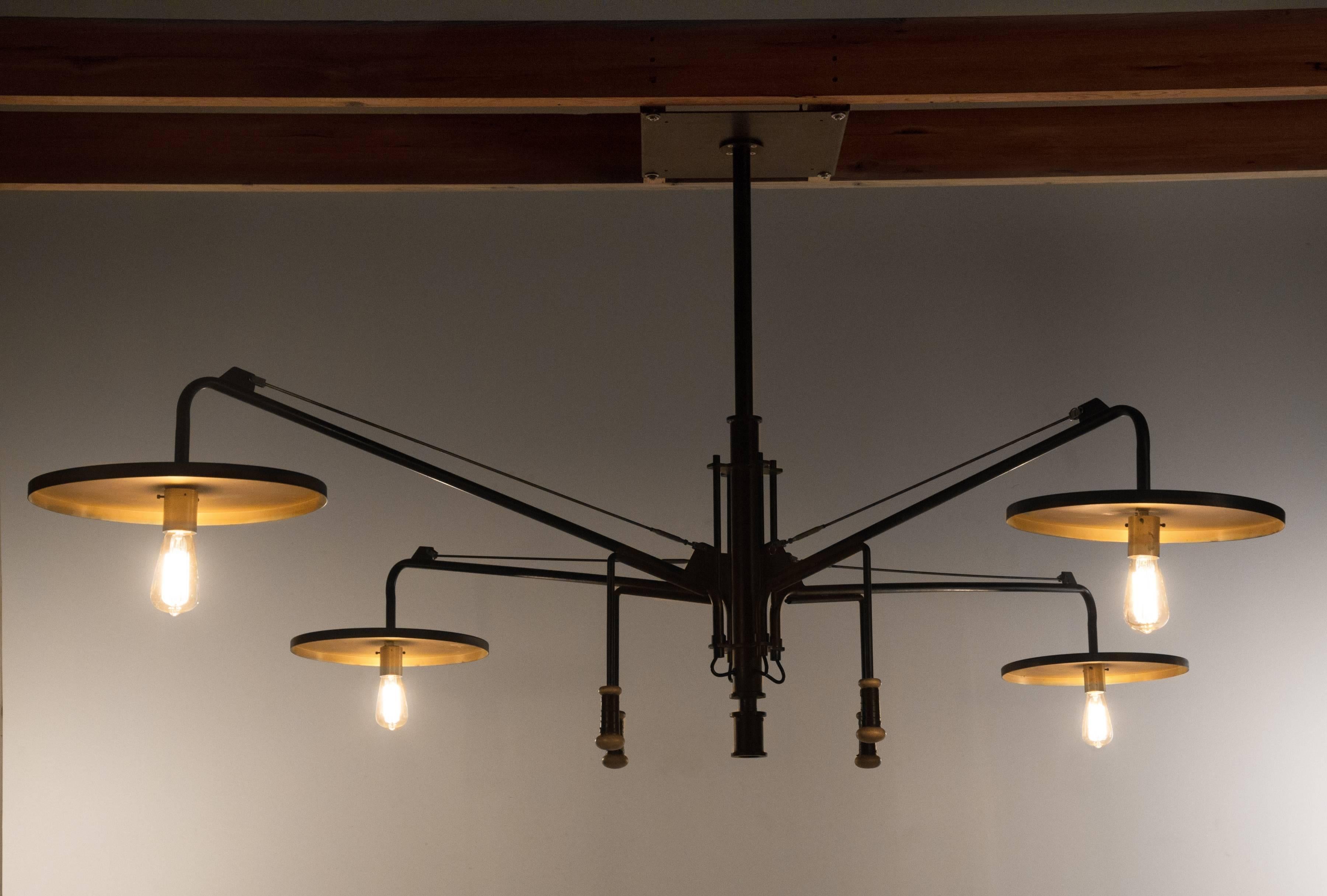 A monumental patinated steel, brass, maple and leather adjustable chandelier made by the lighting and design firm luminaire. As shown in images it is 6 feet 9 inches x 7 feet 4 inches, with a 3 feet 7 inch drop from the ceiling. The maple and