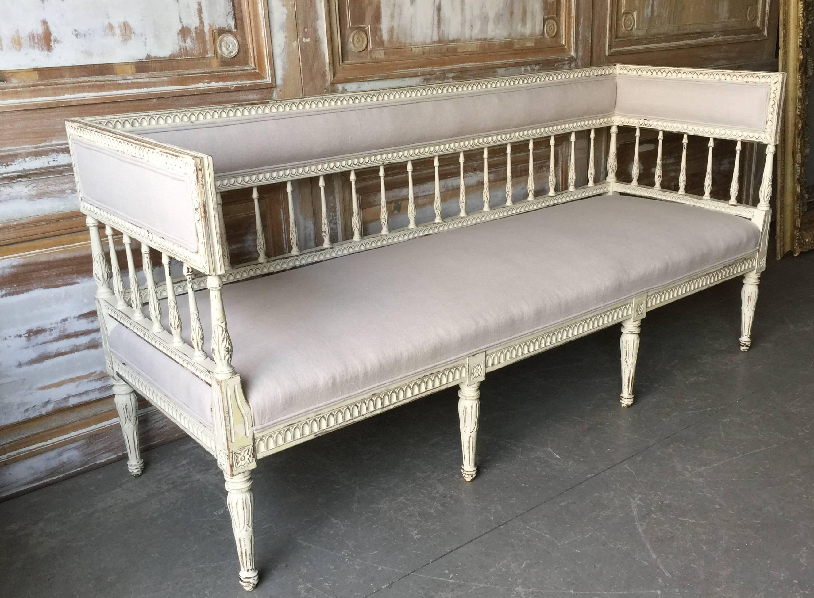 Late 19th century Swedish Gustavian Style sofa with richly carved balustered back and sides and beautifully carved feet with lotus blossoms beneath flower motifs. Reupholstered in very pale gray linen.
Sweden, late 19th century.