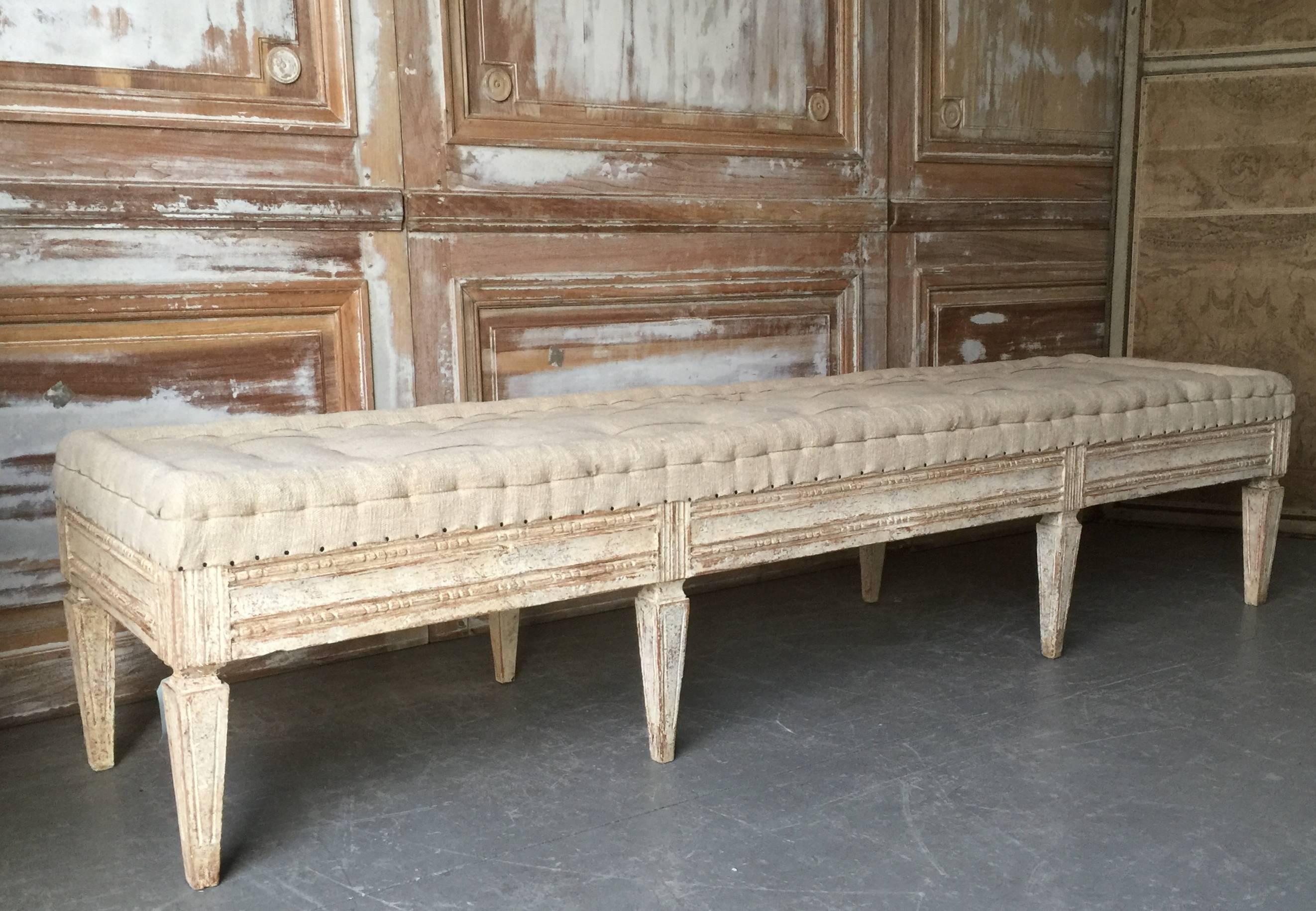 Swedish period Gustavian bench, circa 1800, finished on three sides with beaded rod carvings on carved square tapered legs. Scraped to original cream white finish and upholstered in traditional way in antique hand-stitched linen. Timeless antique