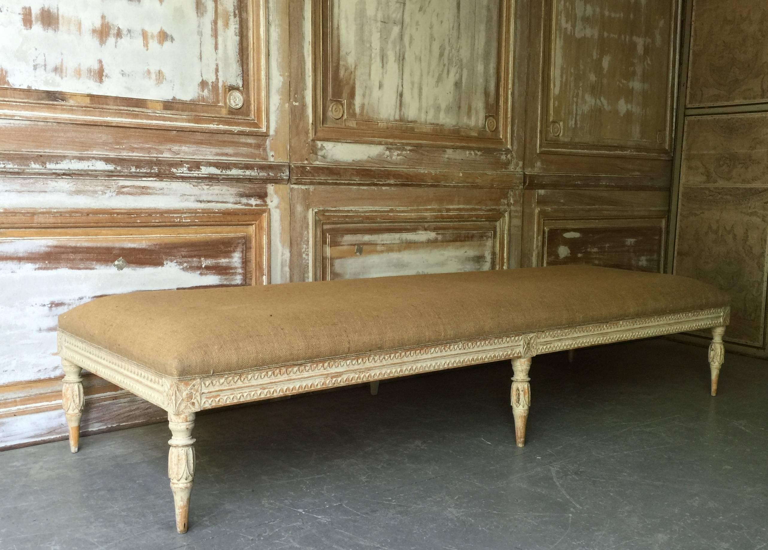 Swedish period Gustavian daybed or large bench, circa 1800, with richly decorated with scrolling carvings to three sides and skillfully carved fluted legs. Time worn patina and upholstered in natural jute. Timeless antique style, ready for your home