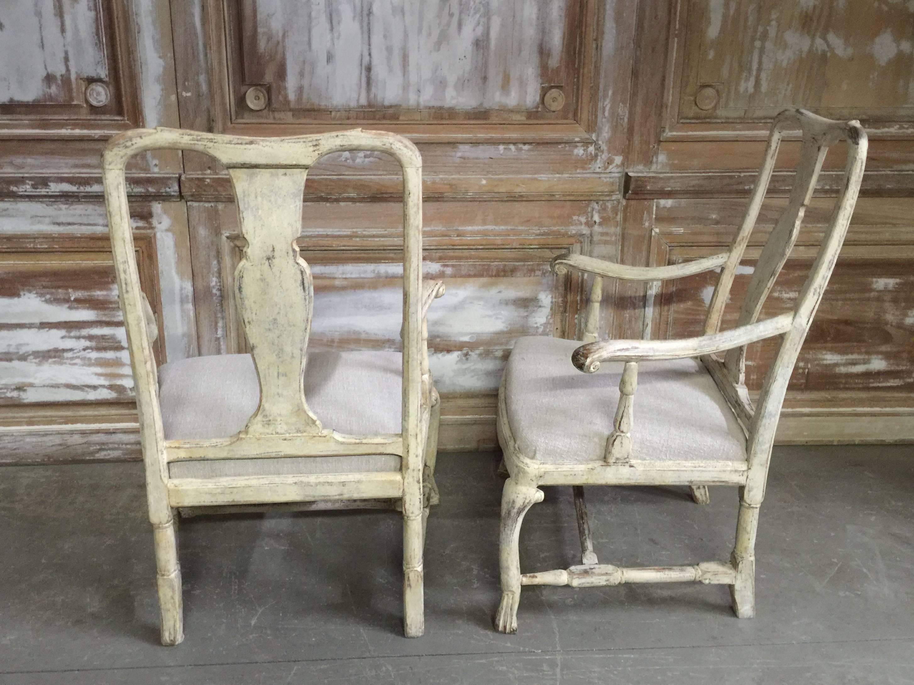 Pair of 18th century Swedish chairs, in Rococo period, circa 1760 with rocaille carving on the seat rails and pierced splats. Hand scraped back to traces of their original worn creamy white paint.
Seats covered with heavy hand loom antique