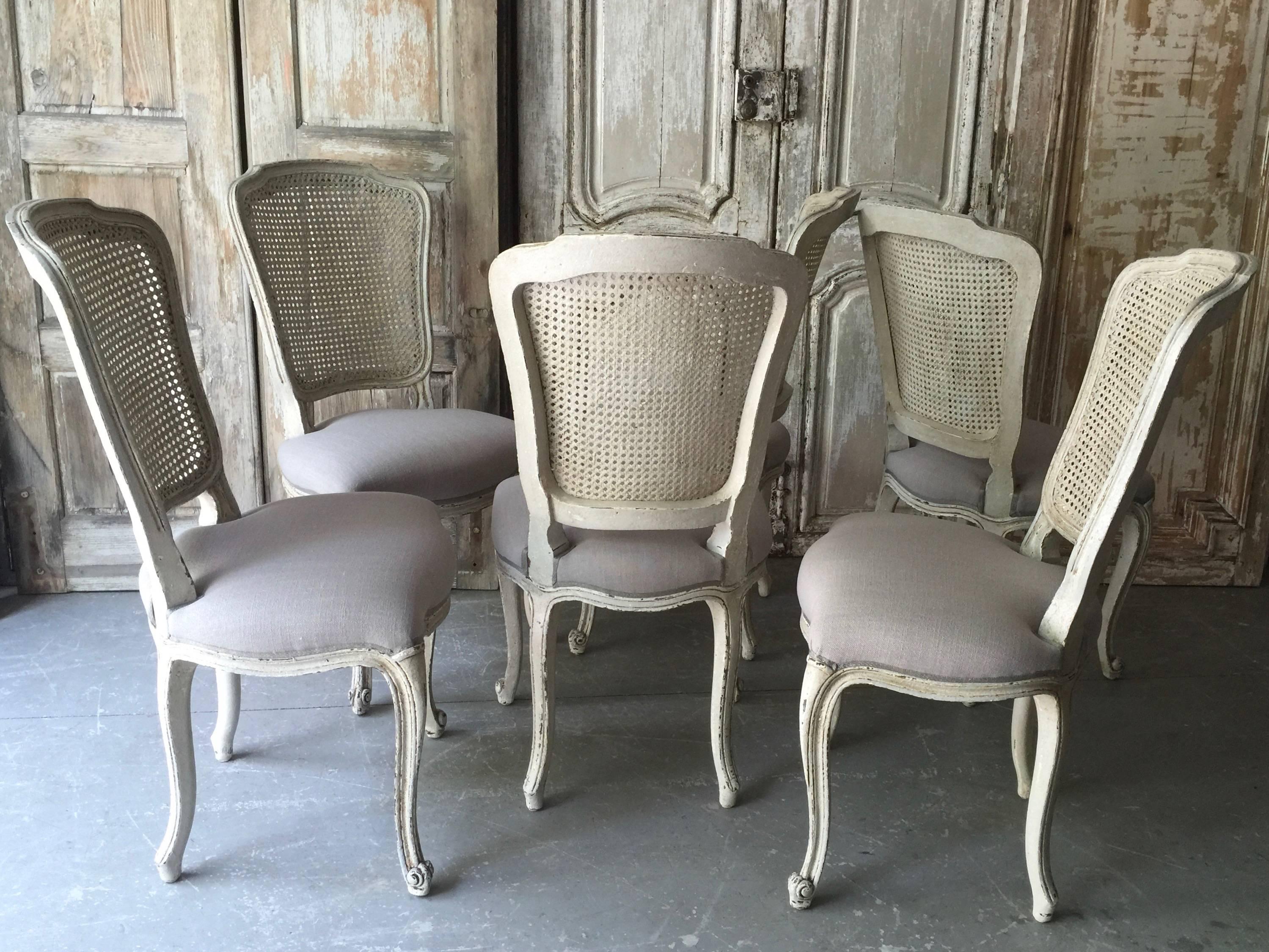 Set of French chairs Louis XV style with flat back called “la Reine” is caned and scalloped frieze carved and raised on cabriole legs. Upholstered in very light gray/natural linen with classical decorative gimp trim. Very elegant as well as
