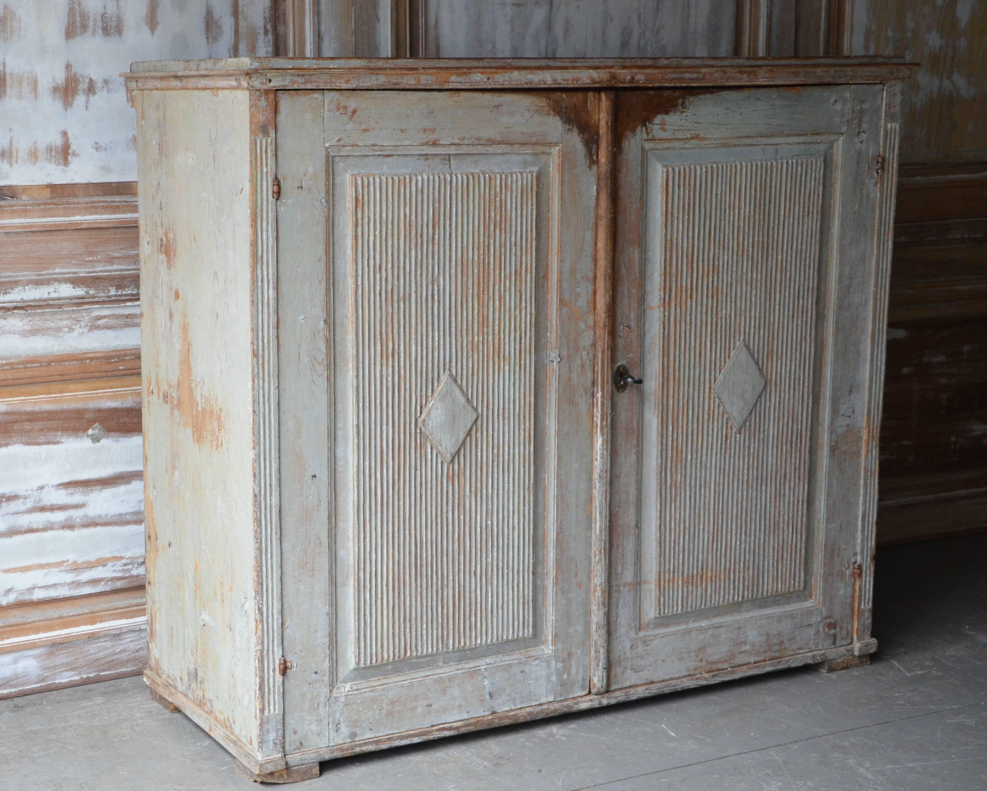 A richly carved Gustavian period sideboard has reeded paneled doors with central diamond shape lozenges, reeded corner posts in wonderful worn pale blue/grey patina. This antique sideboard offers plenty of practical storage,
Stockholm, Sweden,