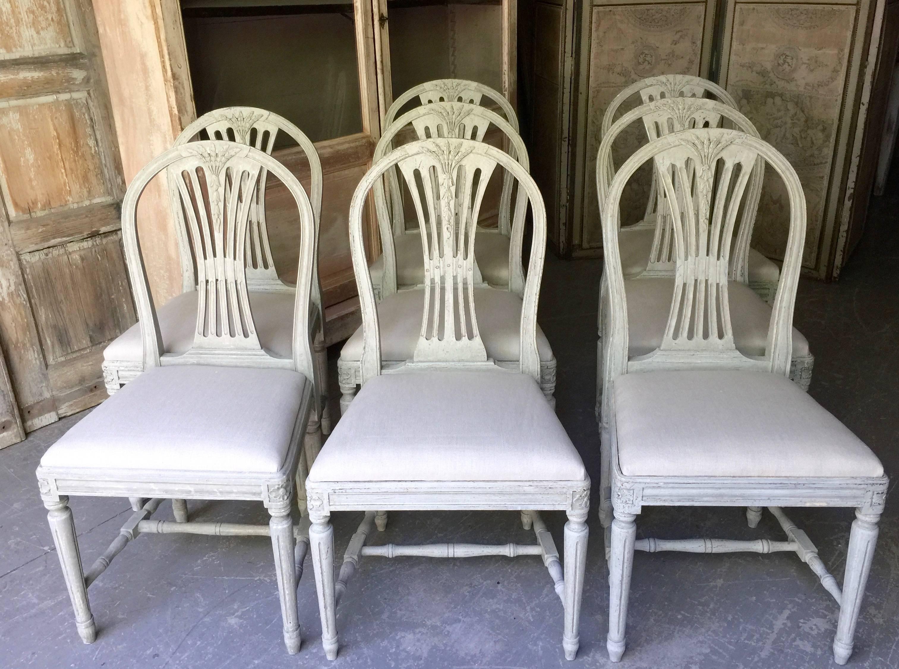 A set of eight 19th century Swedish Gustavian style painted dining chairs with pierced slats and carved weatsheaf details.
Seats covered in lightest gray linen.
Seat size:
19.50