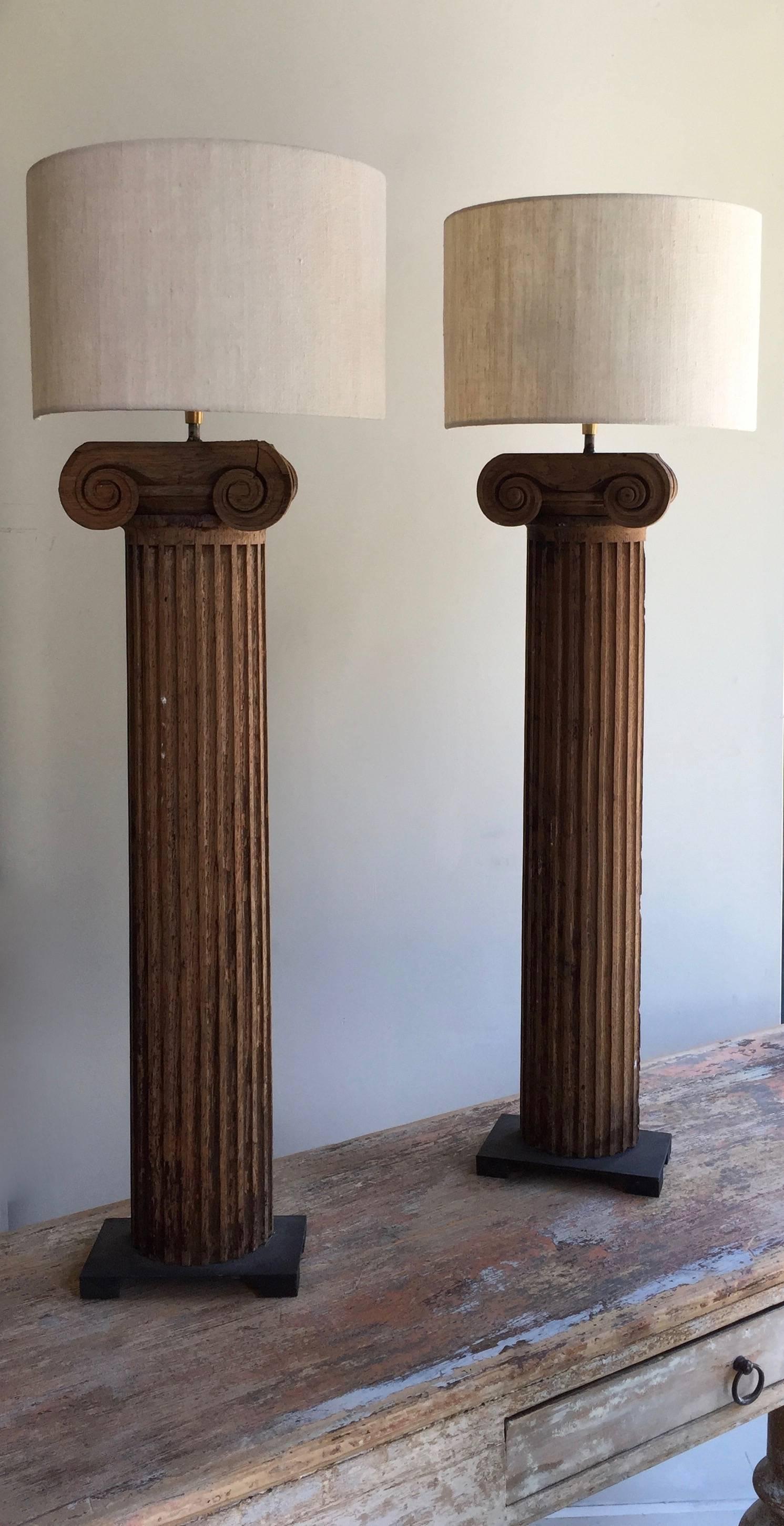 A pair of 19th century richly carved architectural half column fragments made into the table lamps, mounted on iron base and with custom-made half round linen shades from Paris, France.
Measures: Base: 4