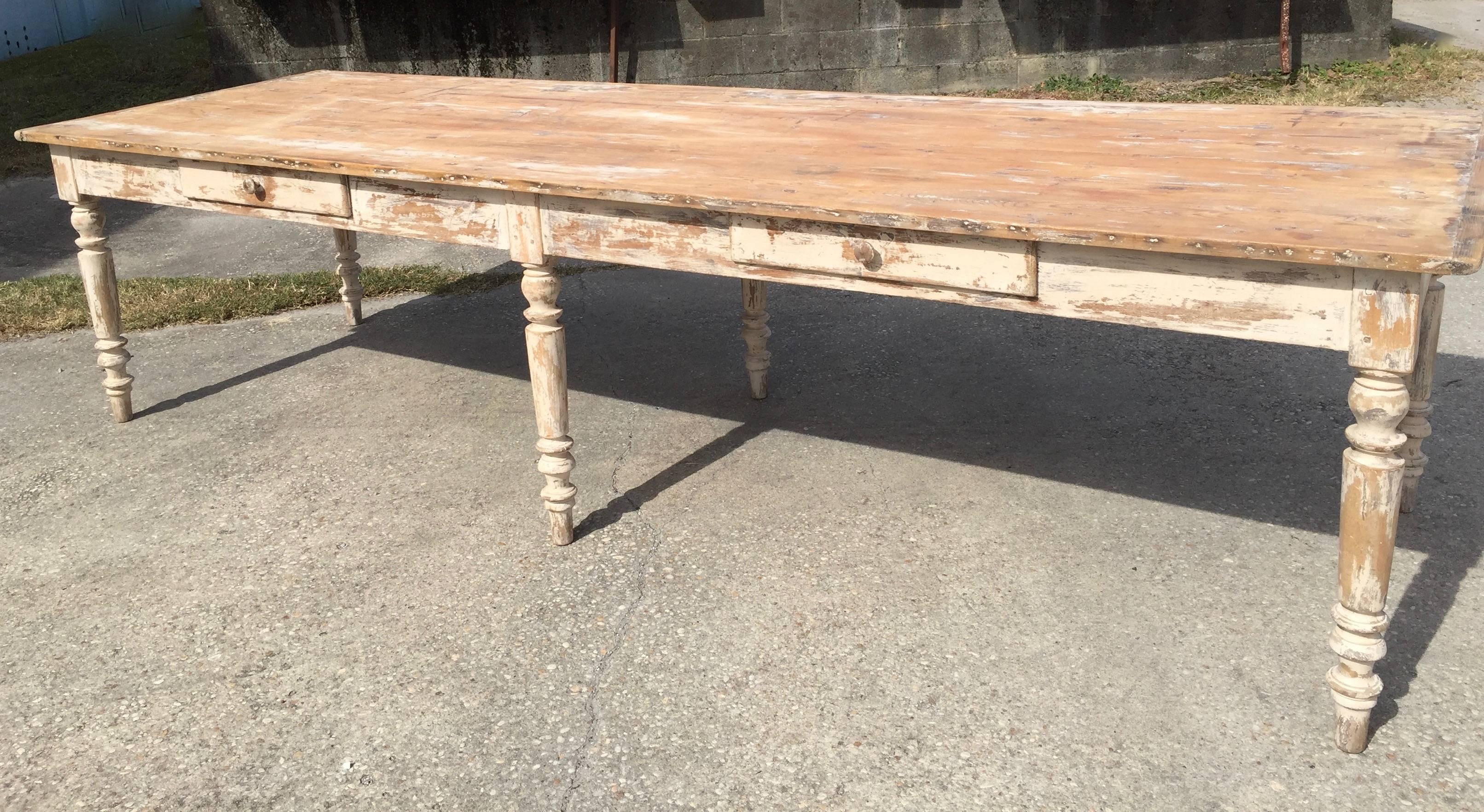 Late 19th century long, wide, primitive, patinated French country table in pine base with oak top, baluster legs and two drawers. 
Surprising pieces and objects, authentic, decorative and rare items. Discover them all.