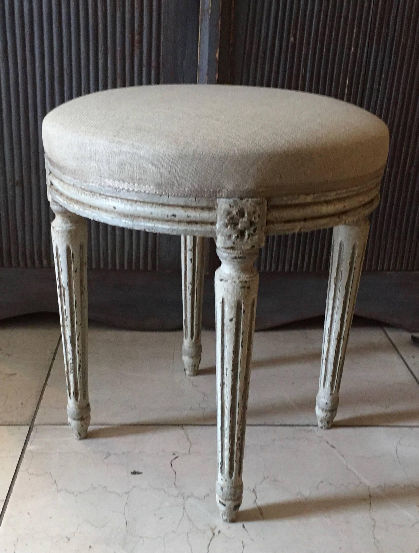 A charming, round in shape, Louis XVI style stool in lovely gray/light blue with legs tapered with flutings and joining dies decorated with a classical daisy motifs. Upholstered in linen fabric, France, circa 1900.
More than ever, we selected the