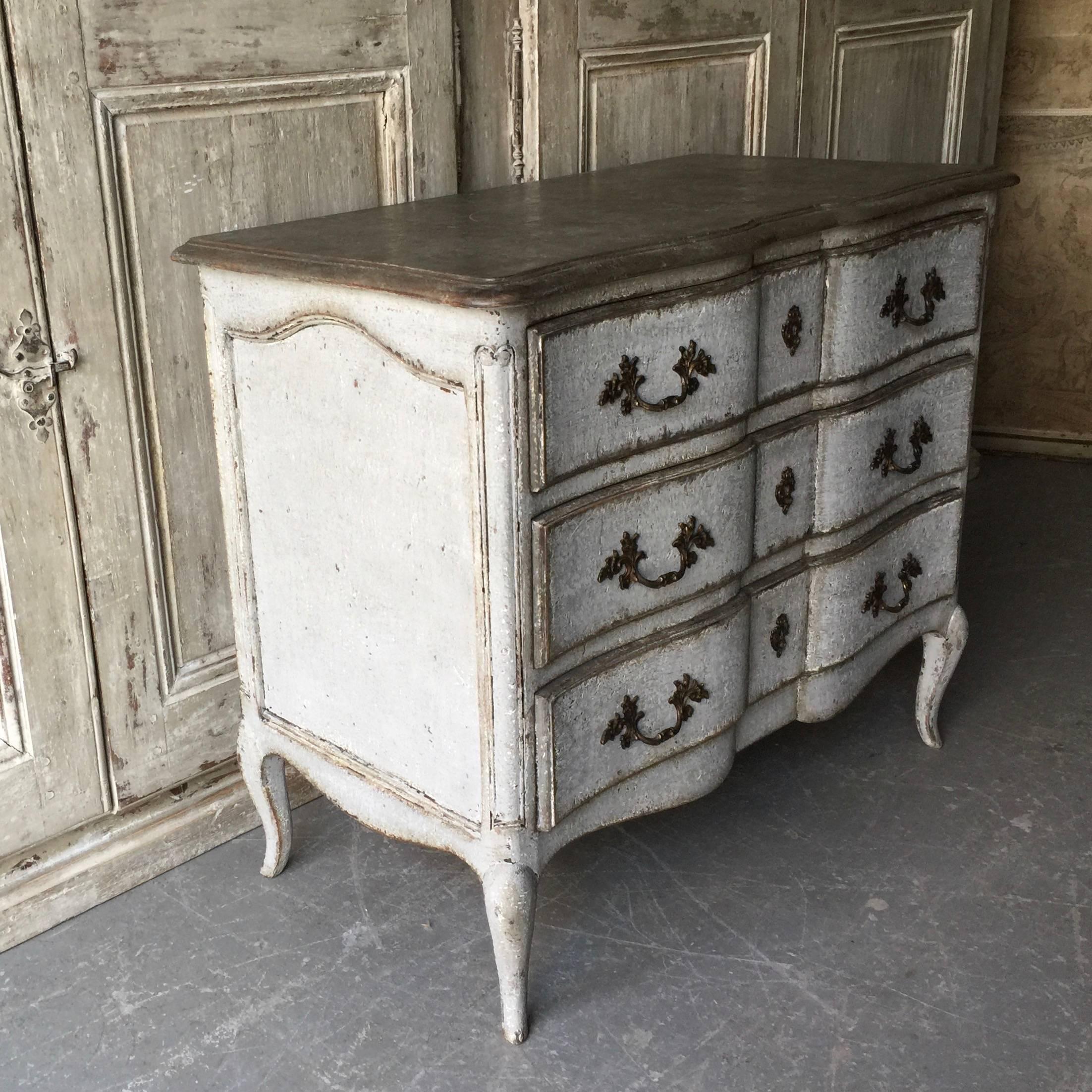 19th century LXV style small, charming commode in worn light blue/gray patina with rounded corners, shaped dark gray top with molded fore-edge and superb decorative bronze keyholes and drop handles on long cabriole legs,
France, circa