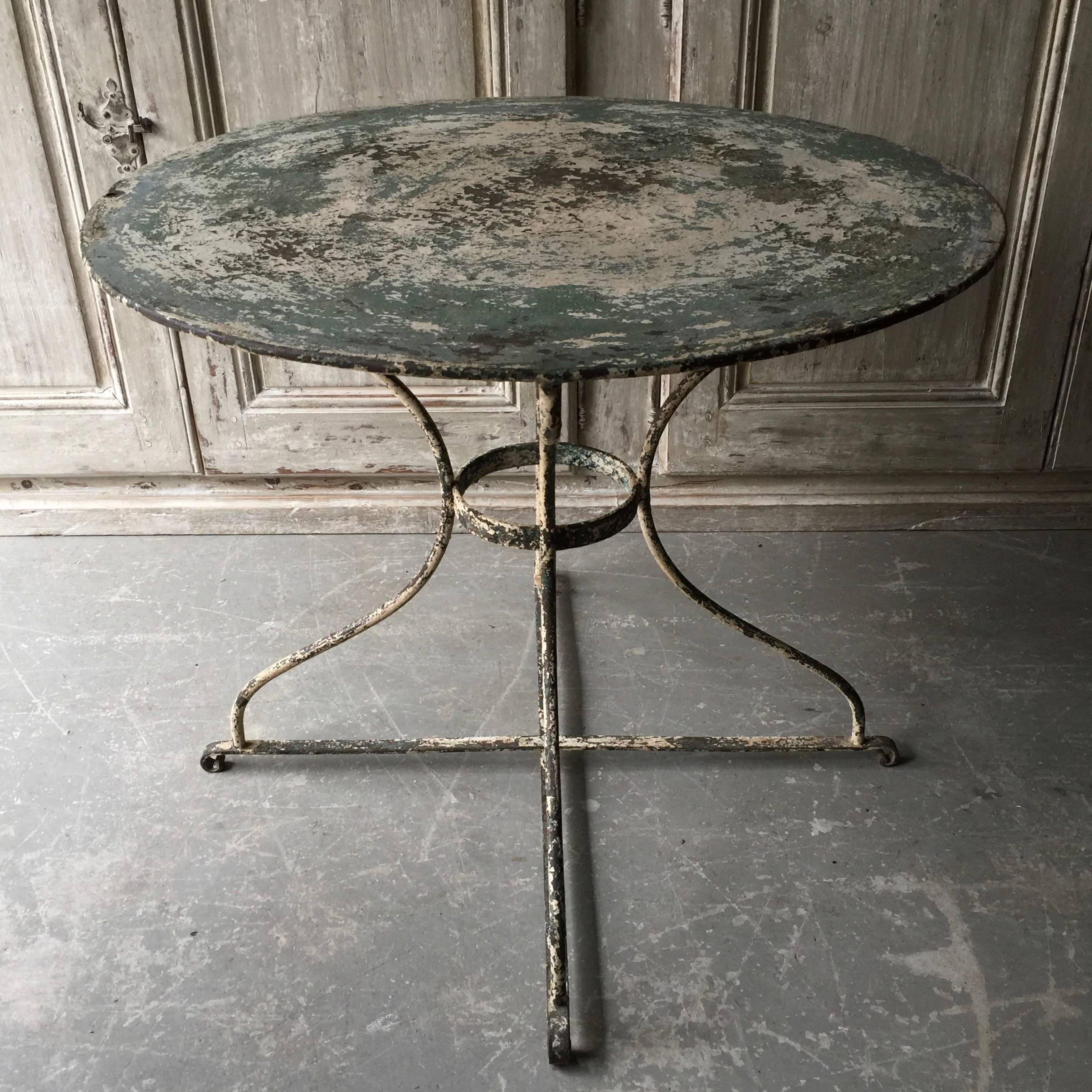 A large 19th century French iron bistro table in worn greenish/white patina.
