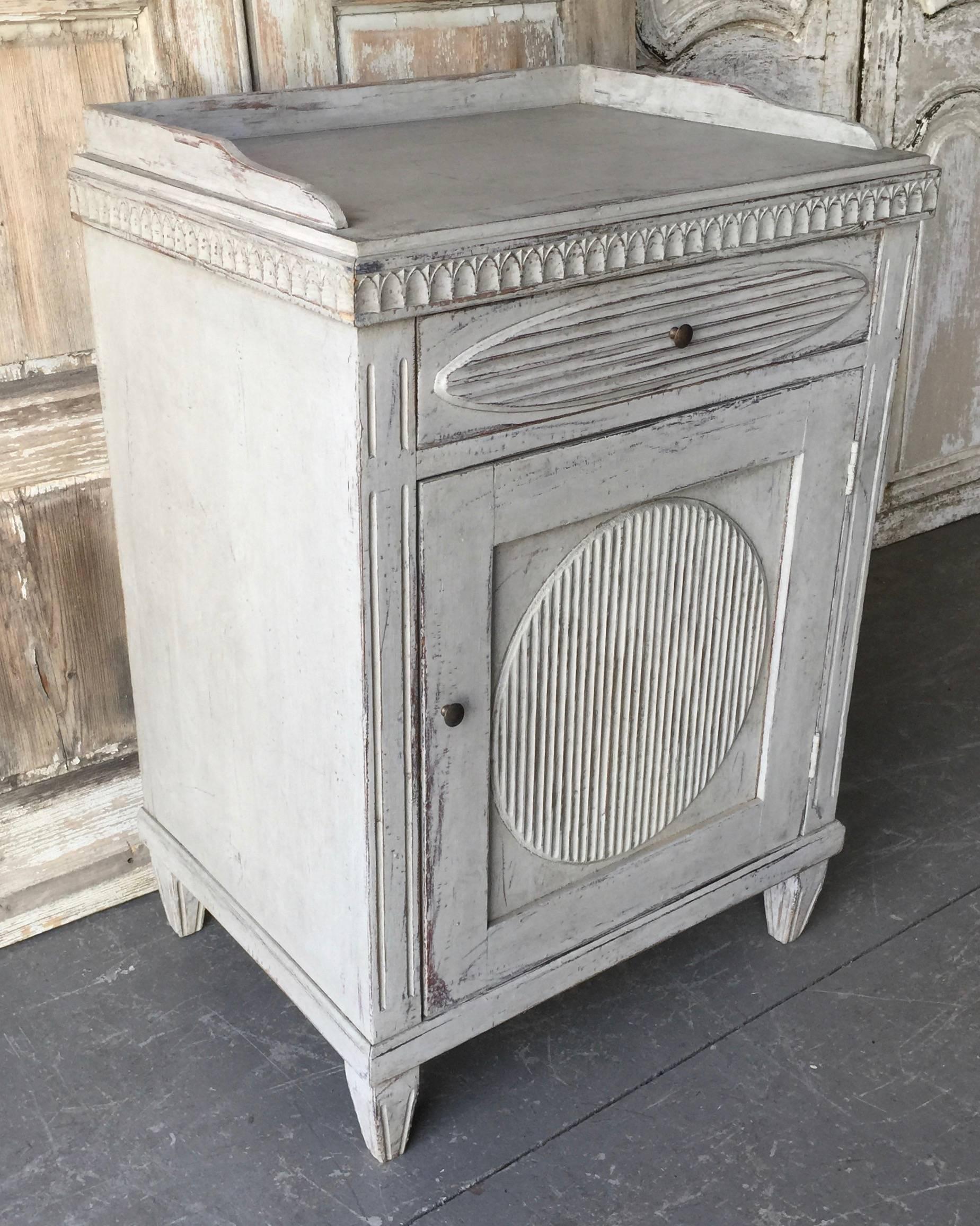A caharming Swedish Late Gustavian side cabinet/ large nightstand with wonderful white/cream time-worn patina, classic proportions with carved paneled door and drawer with a large reeded oval in center, gallery top and tapered legs.
Stockholm,