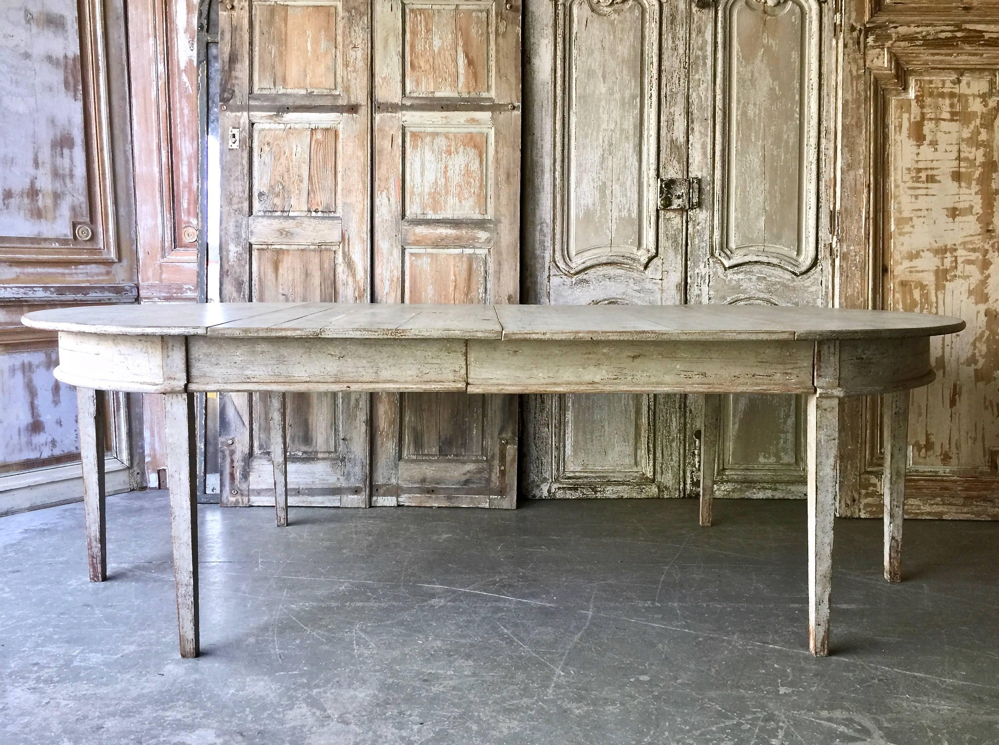 Early 19th century painted Gustavian period extending table with two original leaves and tapered legs. A practical piece that can be used as round table or extended with one or two leaves up to 94