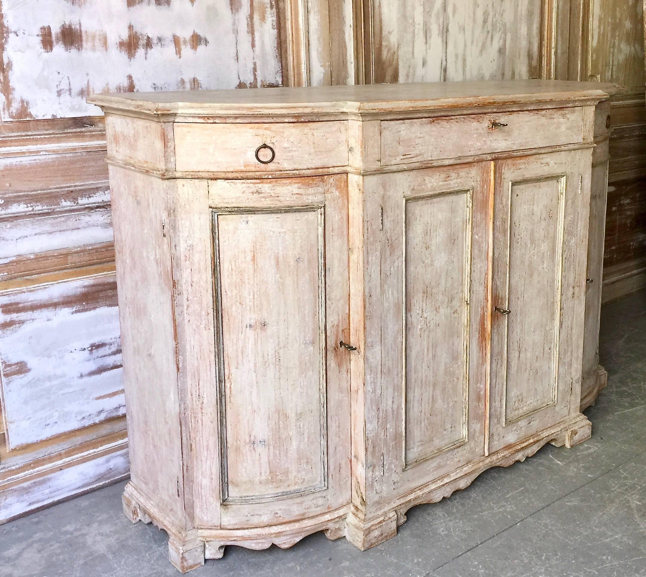 A rare four-door 19th century Swedish Gustavian sideboard with curved panelled doors at each corner and panelled central doors under the shaped top and three drawers on beautifully carved details on front and side skirt.
Stockholm, Sweden, circa