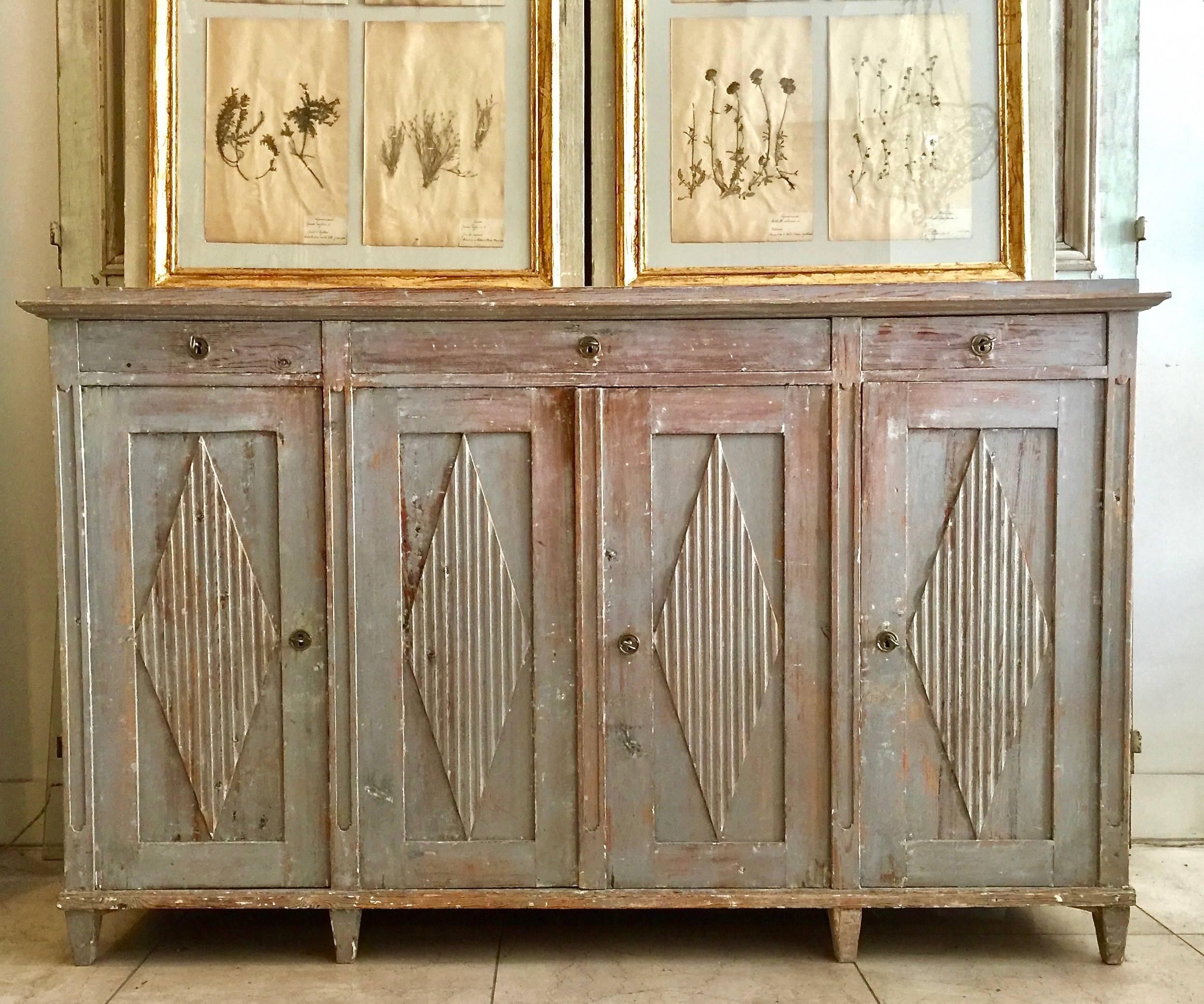 Large 18th century Swedish period Gustavian sideboard in Classic Gustavian style with four panelled doors with reeded diamond shaped lozenges and three large drawers for storage on tapered feet. Wonderful find! 1790-1800 Stockholm,