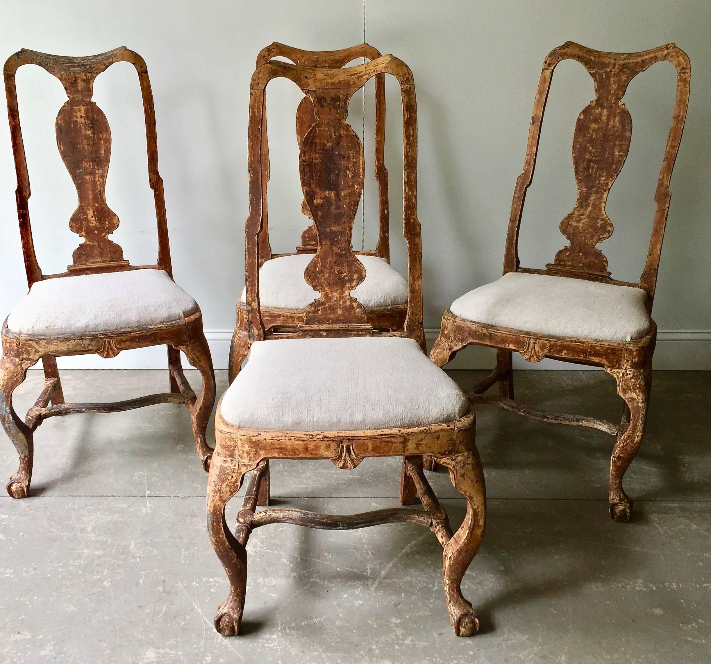 Set of four handsome 18th Century Swedish chairs in Rococo period, circa 1760. Lovingly handmade with richly carving in traces of their original worn patina. Upholstered with antique raw linen. Very elegant chairs, look fantastic with the antique