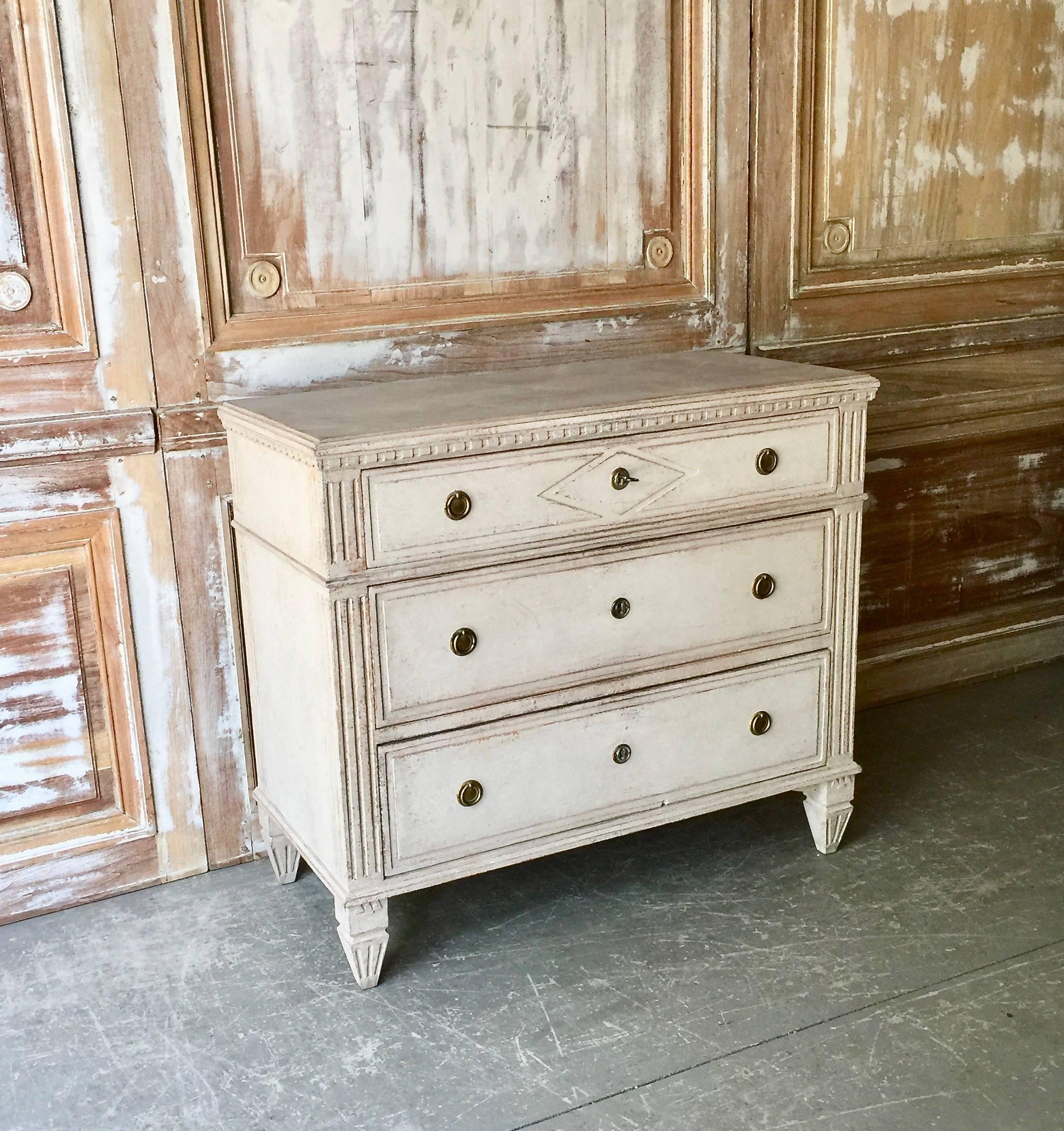 Gustavian period chest of drawers with Classic dental trim to the top, canted posts with fluted details, raised diamond shaped lozenge on upper drawer front and fluted tapered feet under the darker gray-shaped marbleized top,
Sweden, circa